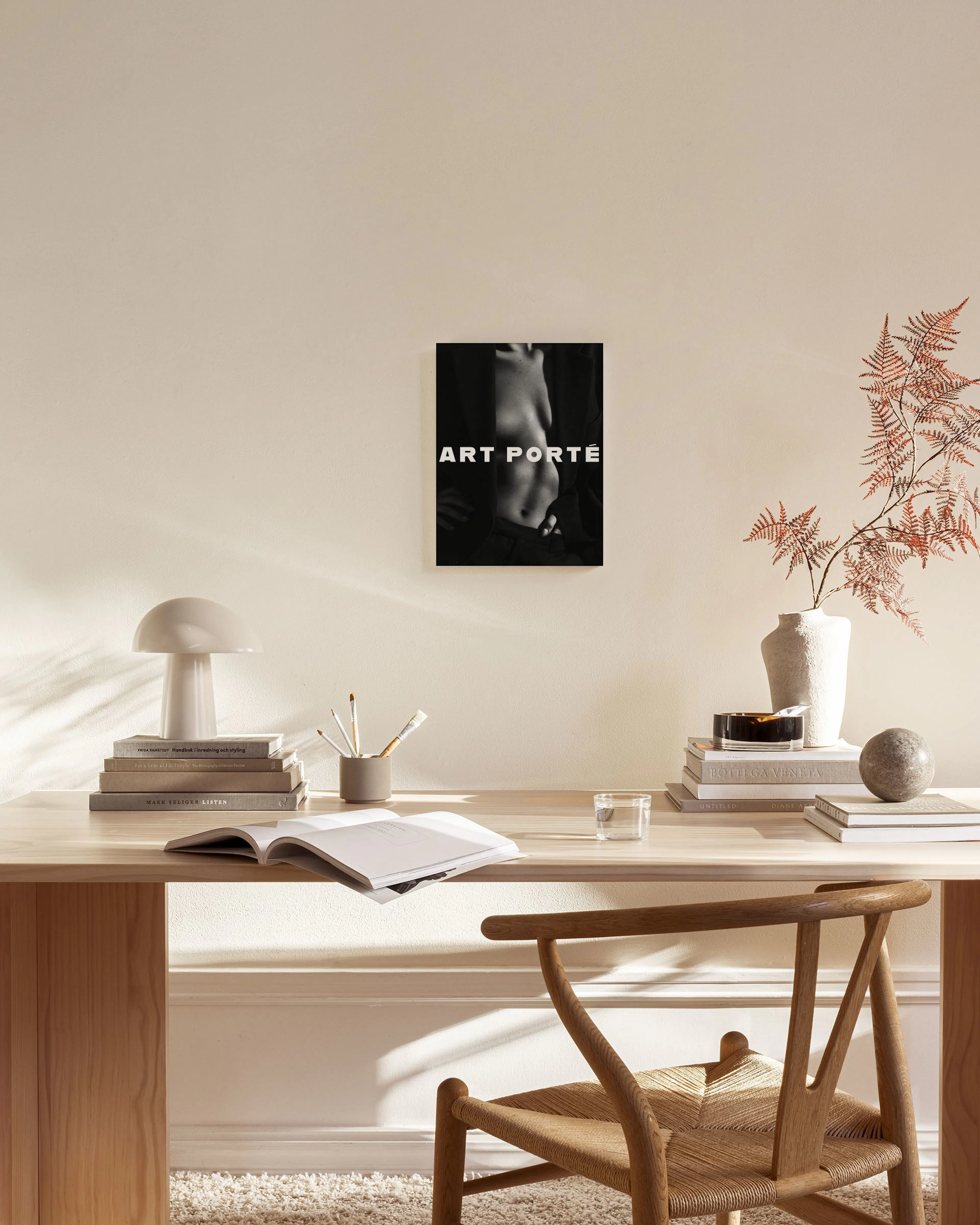 Zwart-wit canvas van een vrouwelijk torso met de tekst ART PORTÉ, hangend boven een houten dressoir in een minimalistische woonk