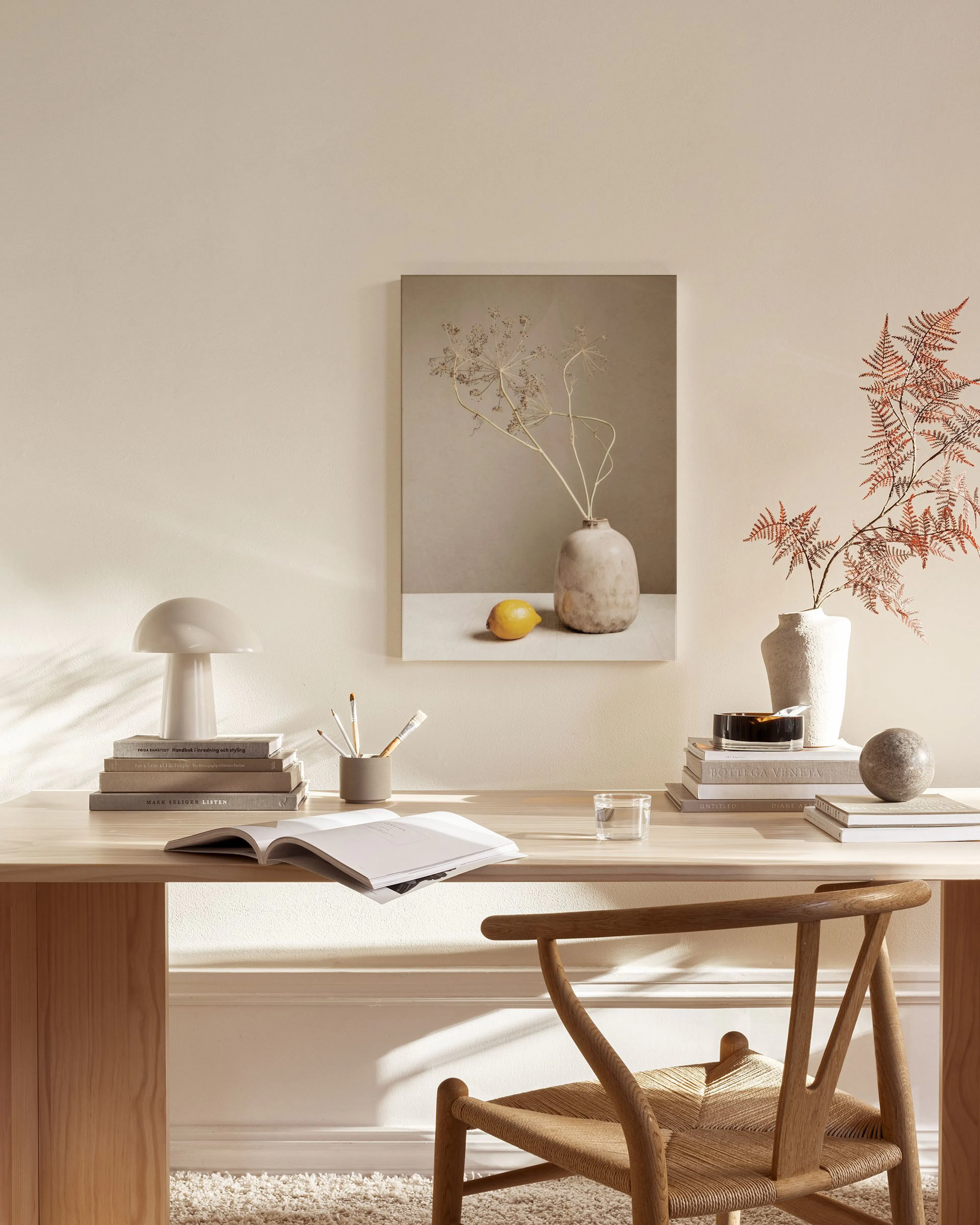 Toile murale décorative: nature morte avec vase, branches séchées et citron, dans un salon moderne aux tons neutres.
