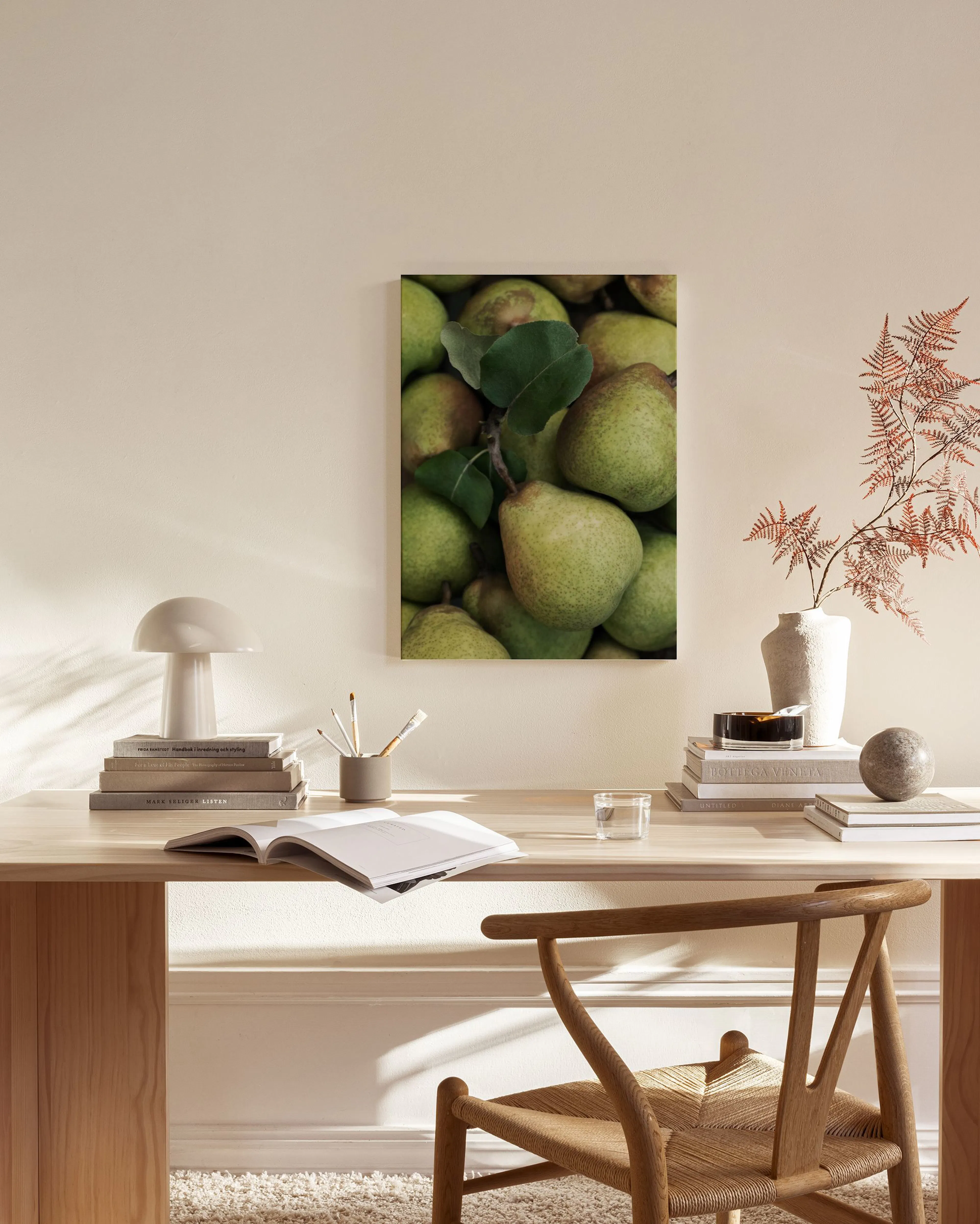 Leinwandbild mit Nahaufnahme von grünen Birnen und Blättern, hängend in einem hellen Wohnzimmer über einem Sideboard.