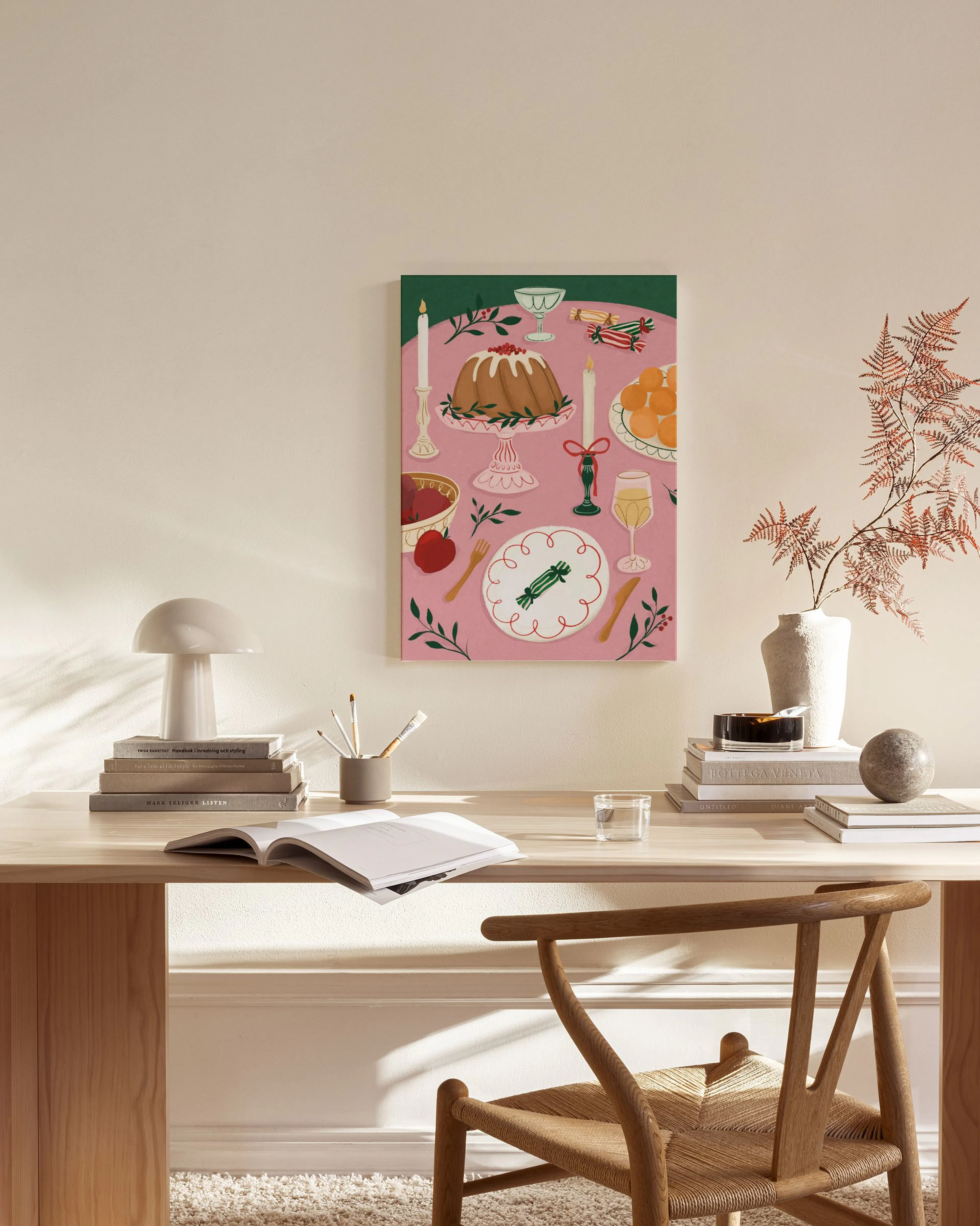 Canvastavla med en dukad frukost på rosa bakgrund, hängande i ett ljust vardagsrum med en fåtölj och soffbord.