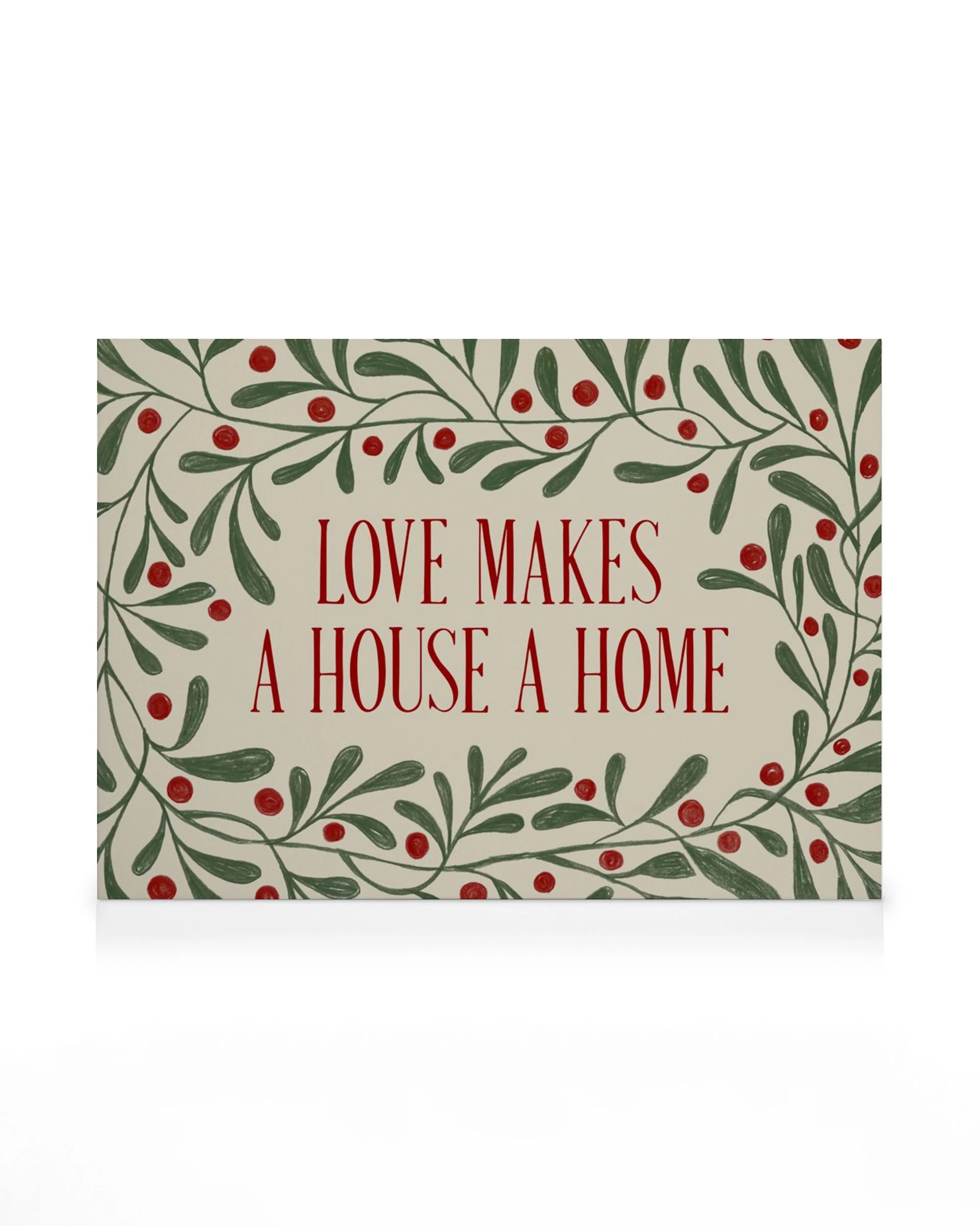 Love Makes a House a Home canvas print with red text surrounded by green leaves and red berries