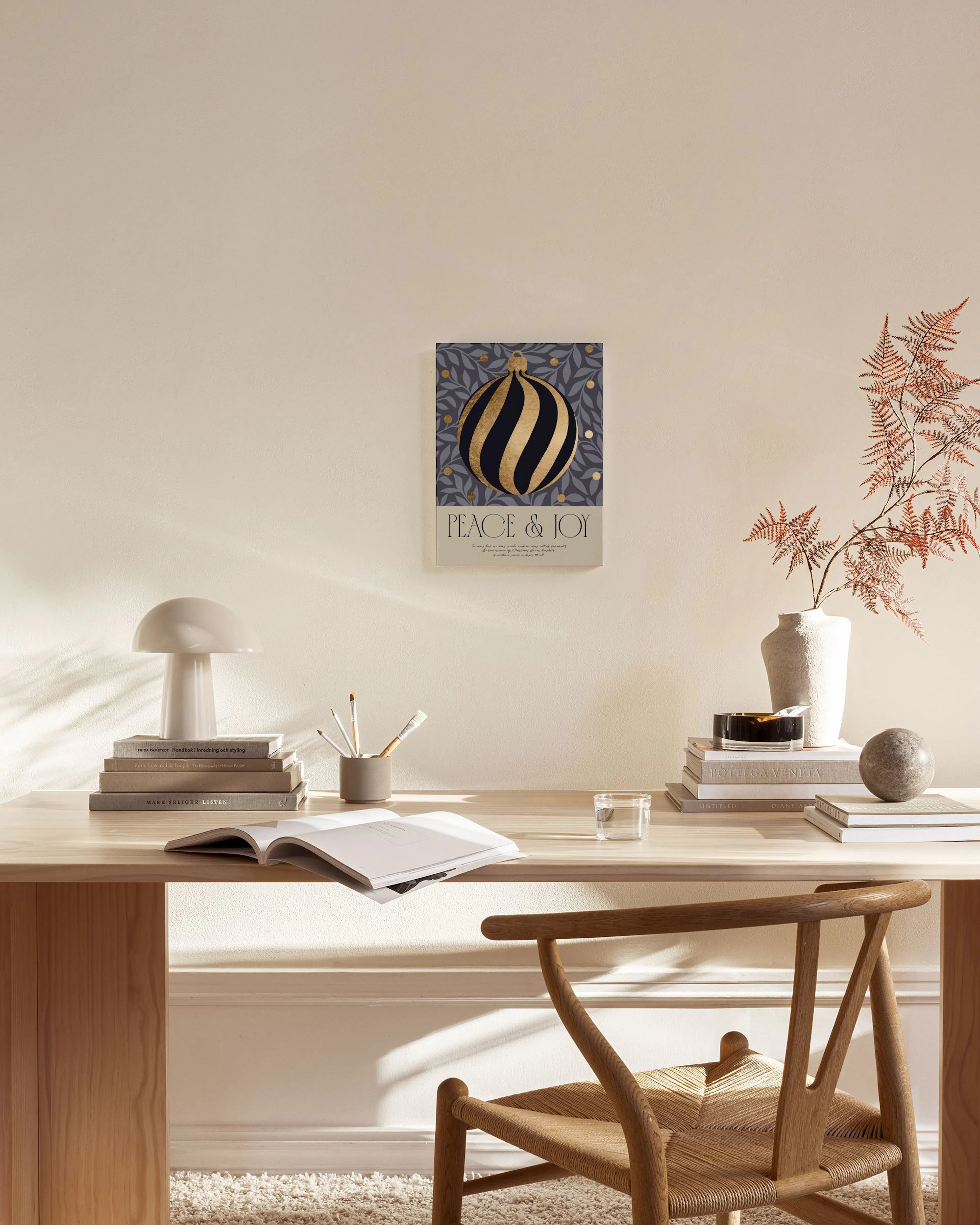 A Christmas canvas print with a gold-striped ornament on a blue floral background, hanging in a cozy living room.