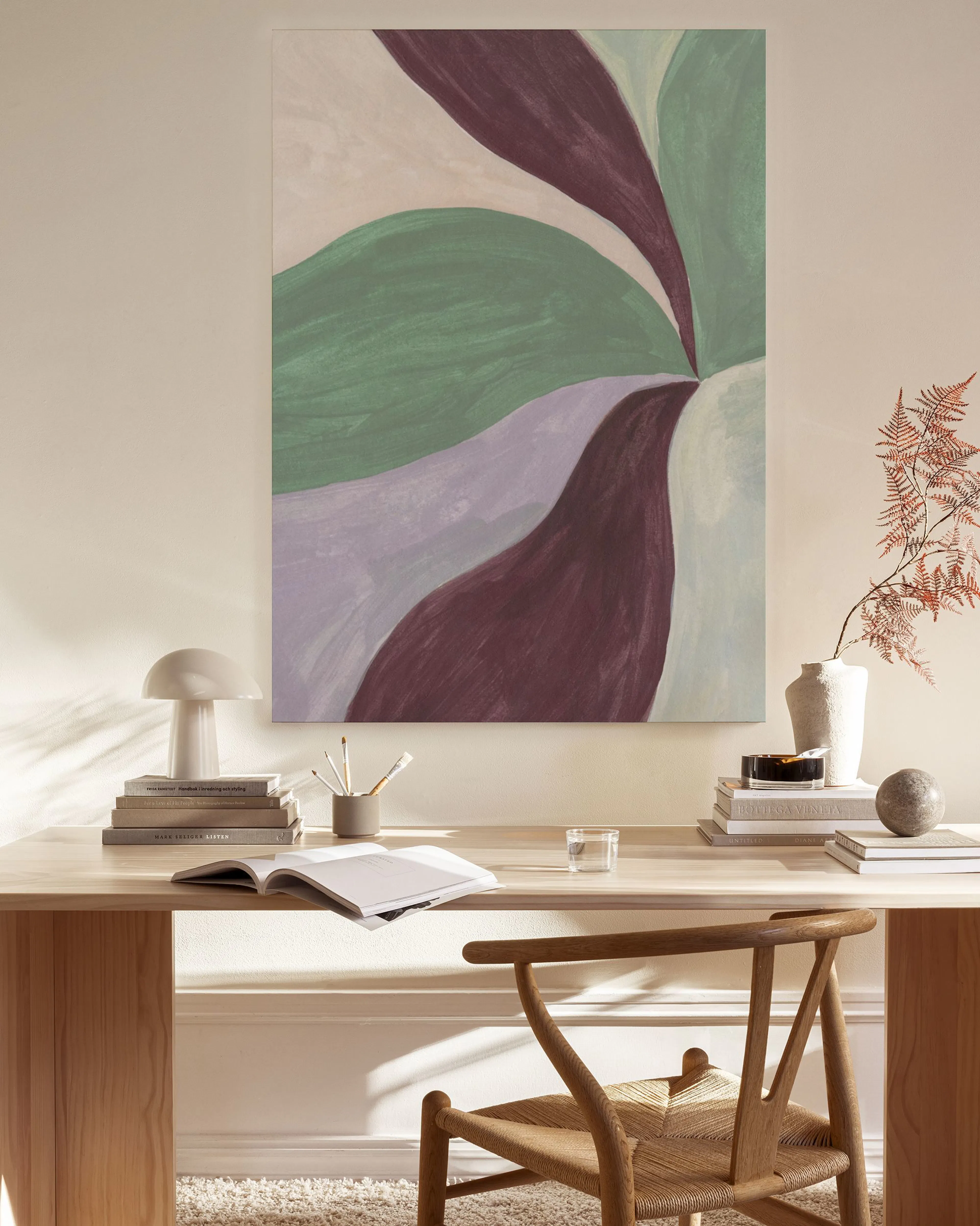 Abstract canvas print with green, purple, and burgundy organic shapes, displayed in a modern living room.