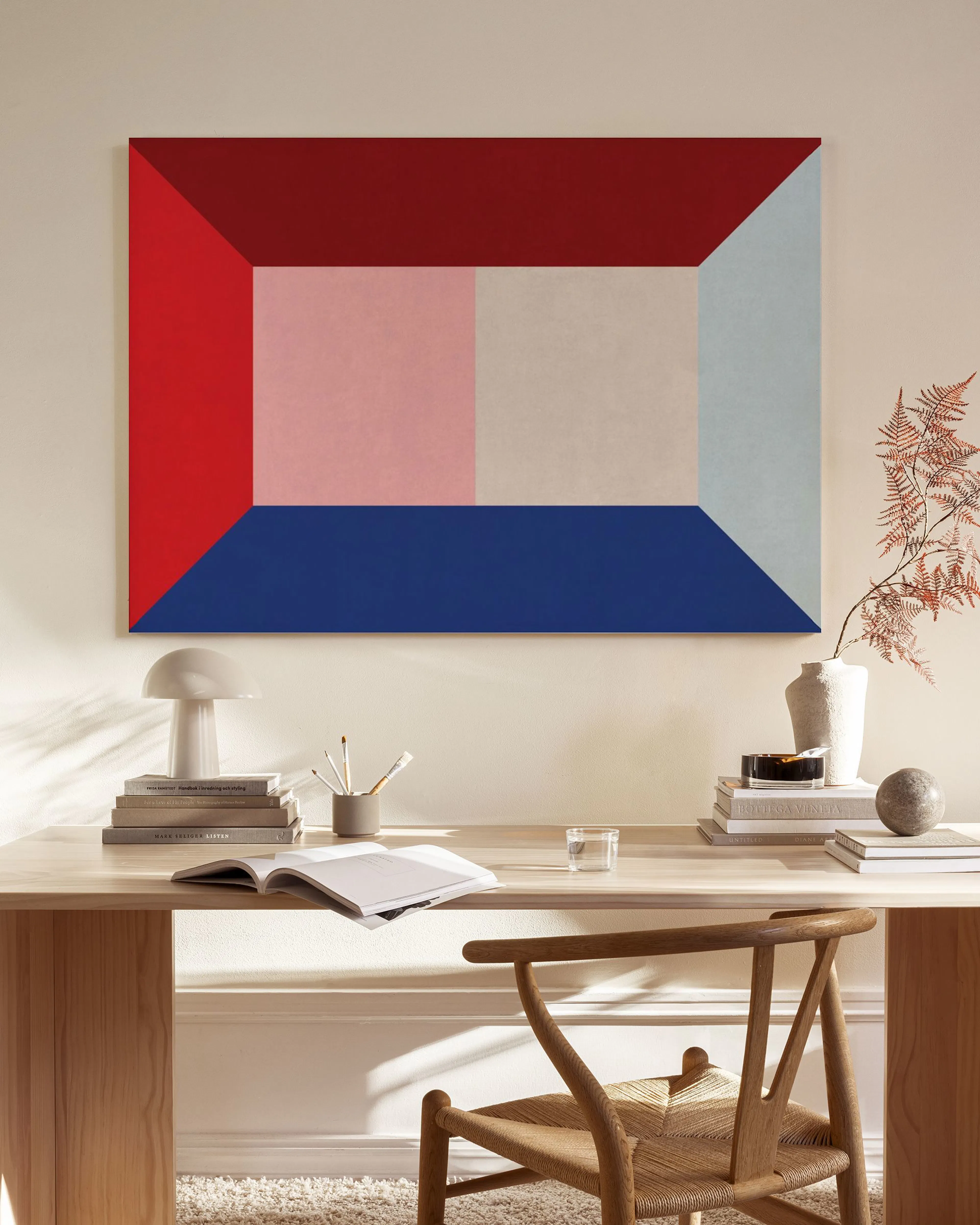 Leinwandbild mit roten, blauen und rosafarbenen geometrischen Formen, aufgehängt in einem modernen Wohnzimmer über einem Sideboa