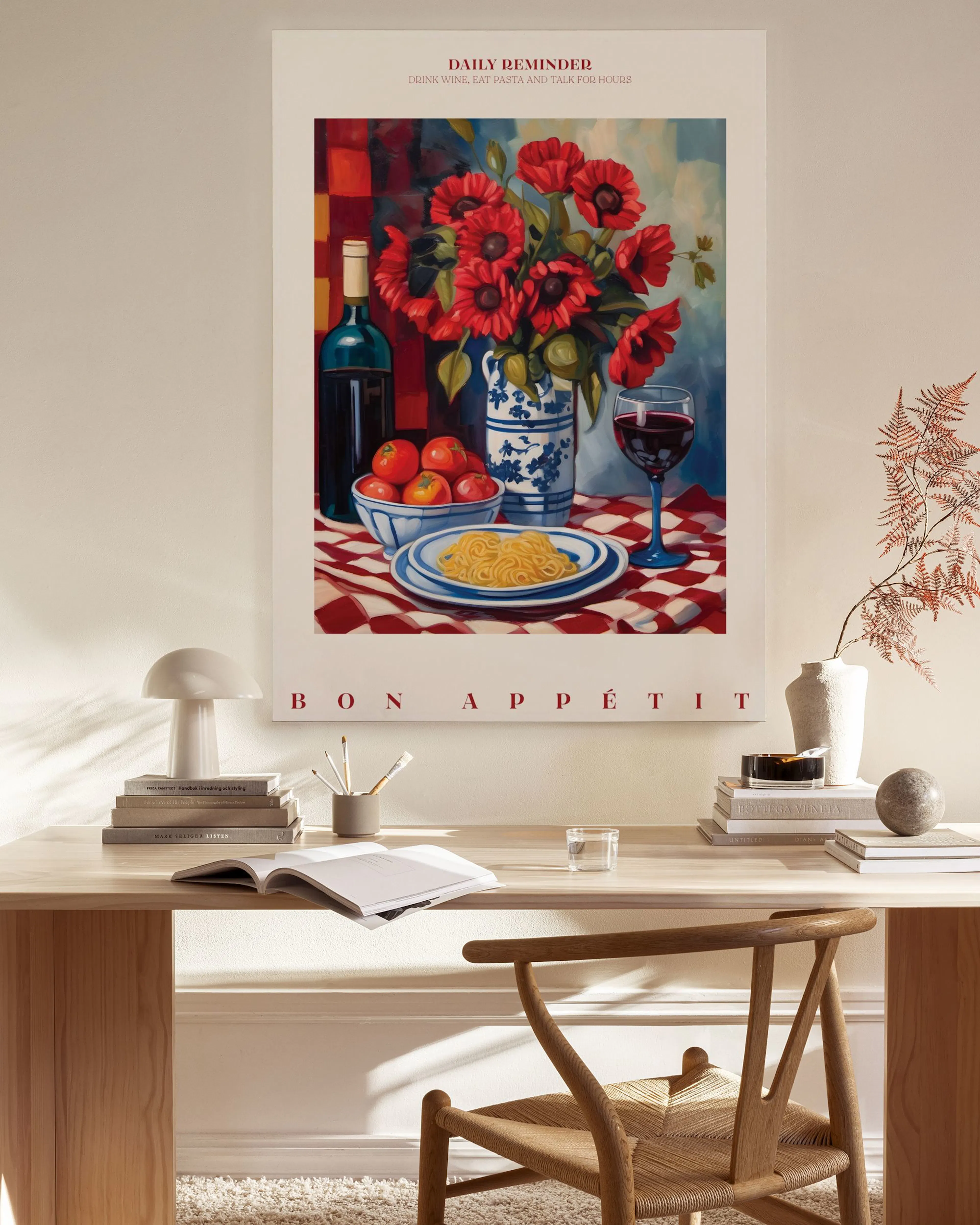 A canvas print of a still life with red flowers, wine bottle, pasta, and fruit, hanging in a minimalist living room.