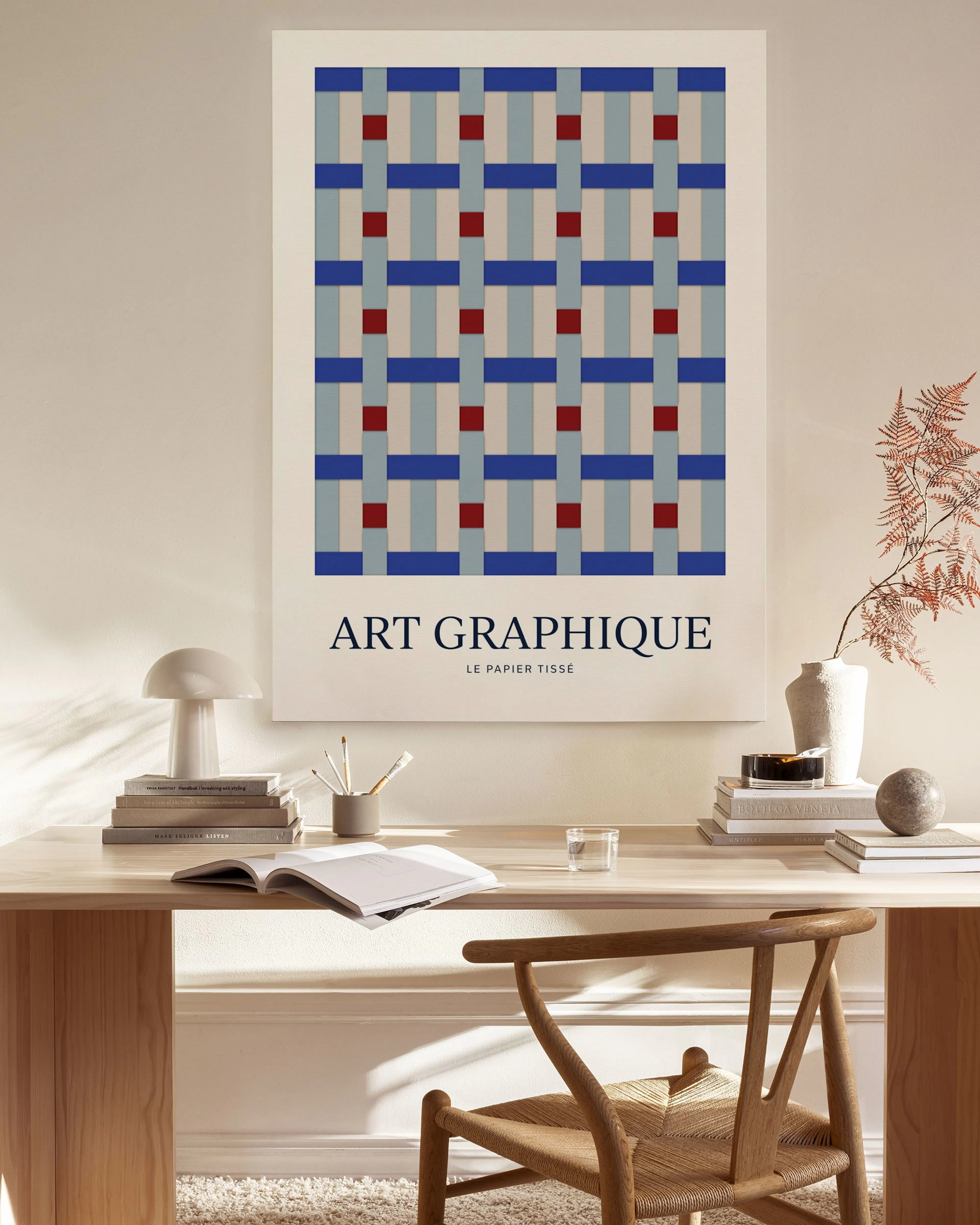 Leinwandbild mit blau-rotem geometrischem Muster, über einem Sideboard in einem beige eingerichteten Wohnzimmer.