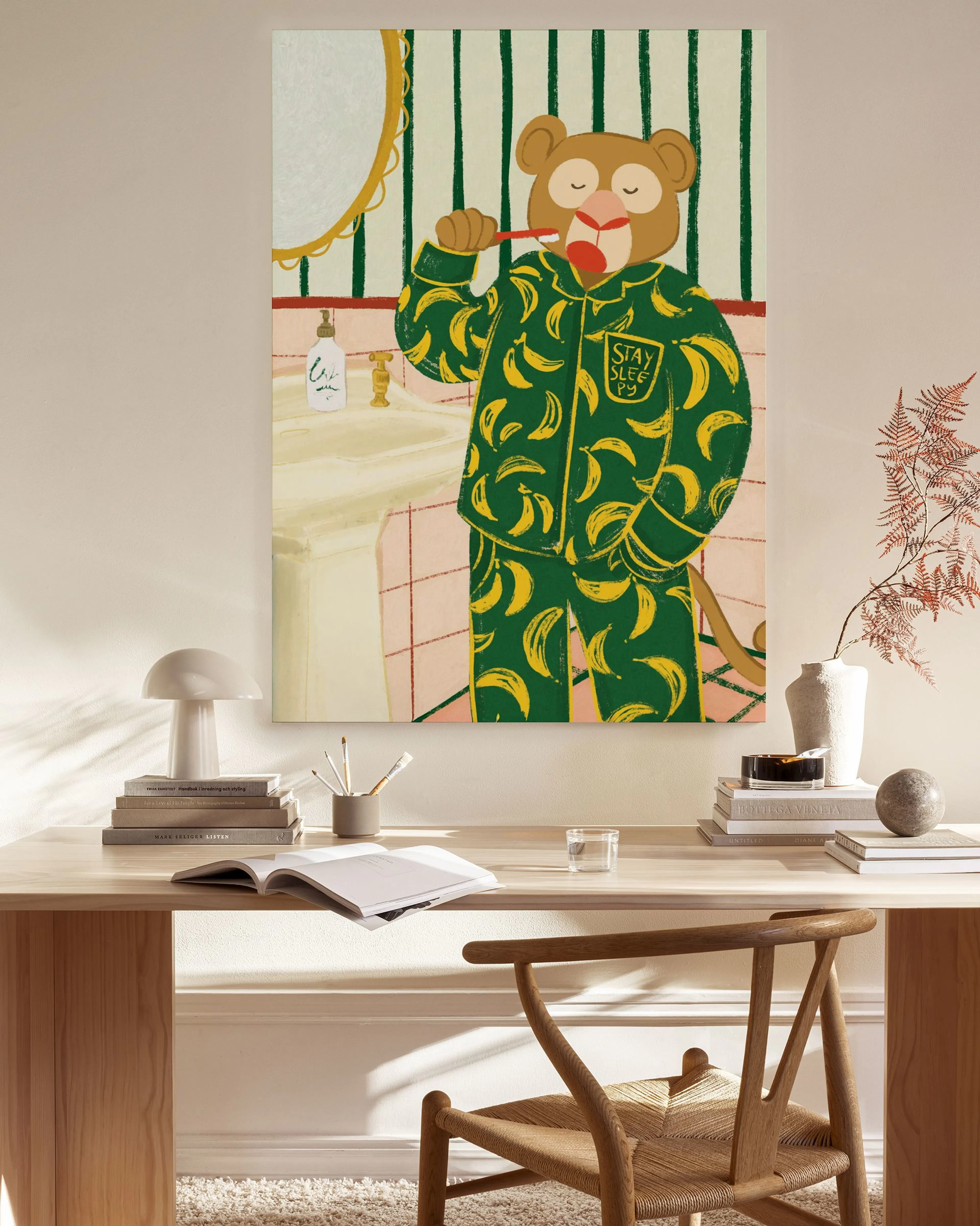 A canvas print of a monkey in banana pyjamas brushing its teeth, hanging in a bright living room above a wooden console.