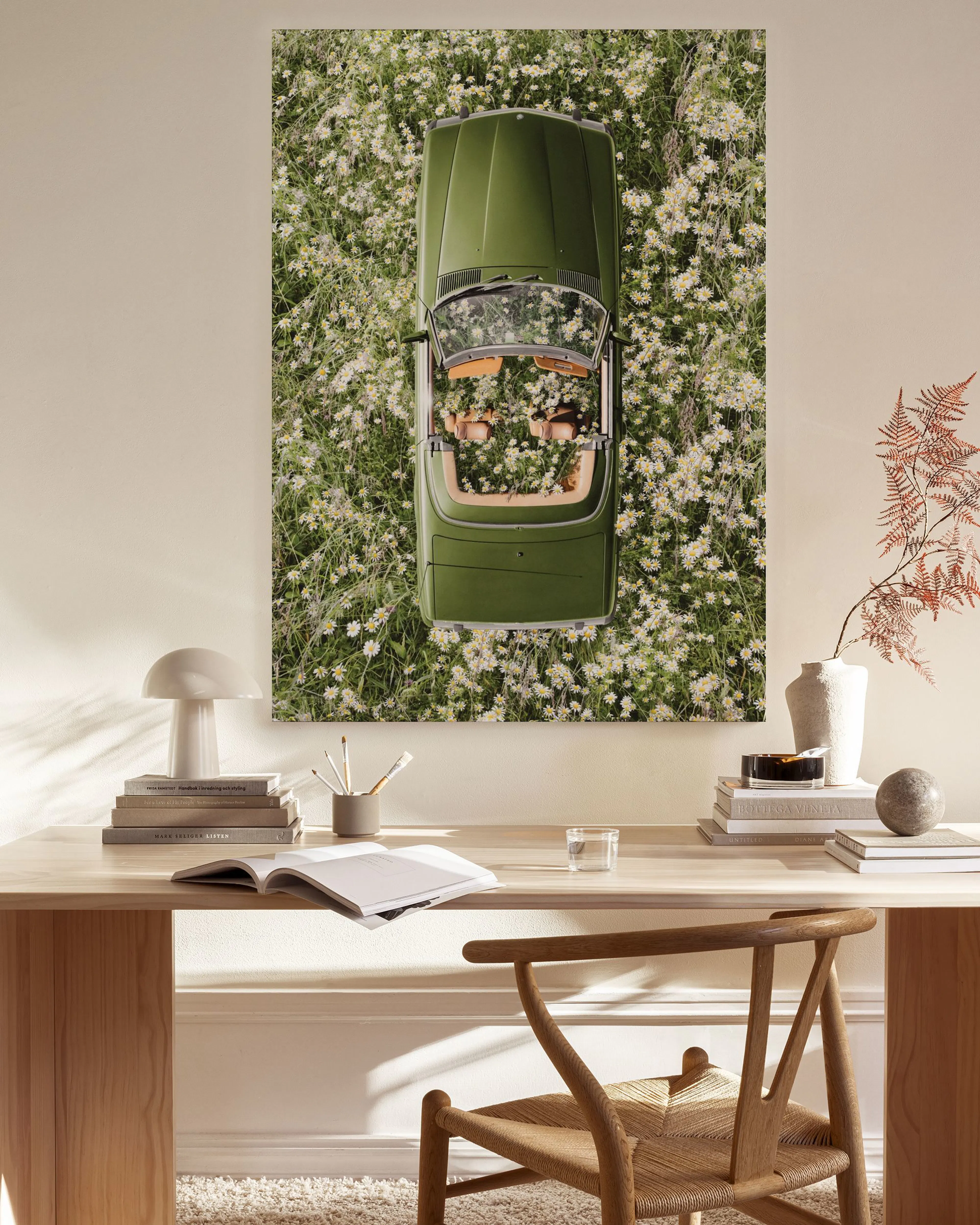 Toile dune voiture verte décapotable au milieu de fleurs blanches, accrochée dans un salon moderne.