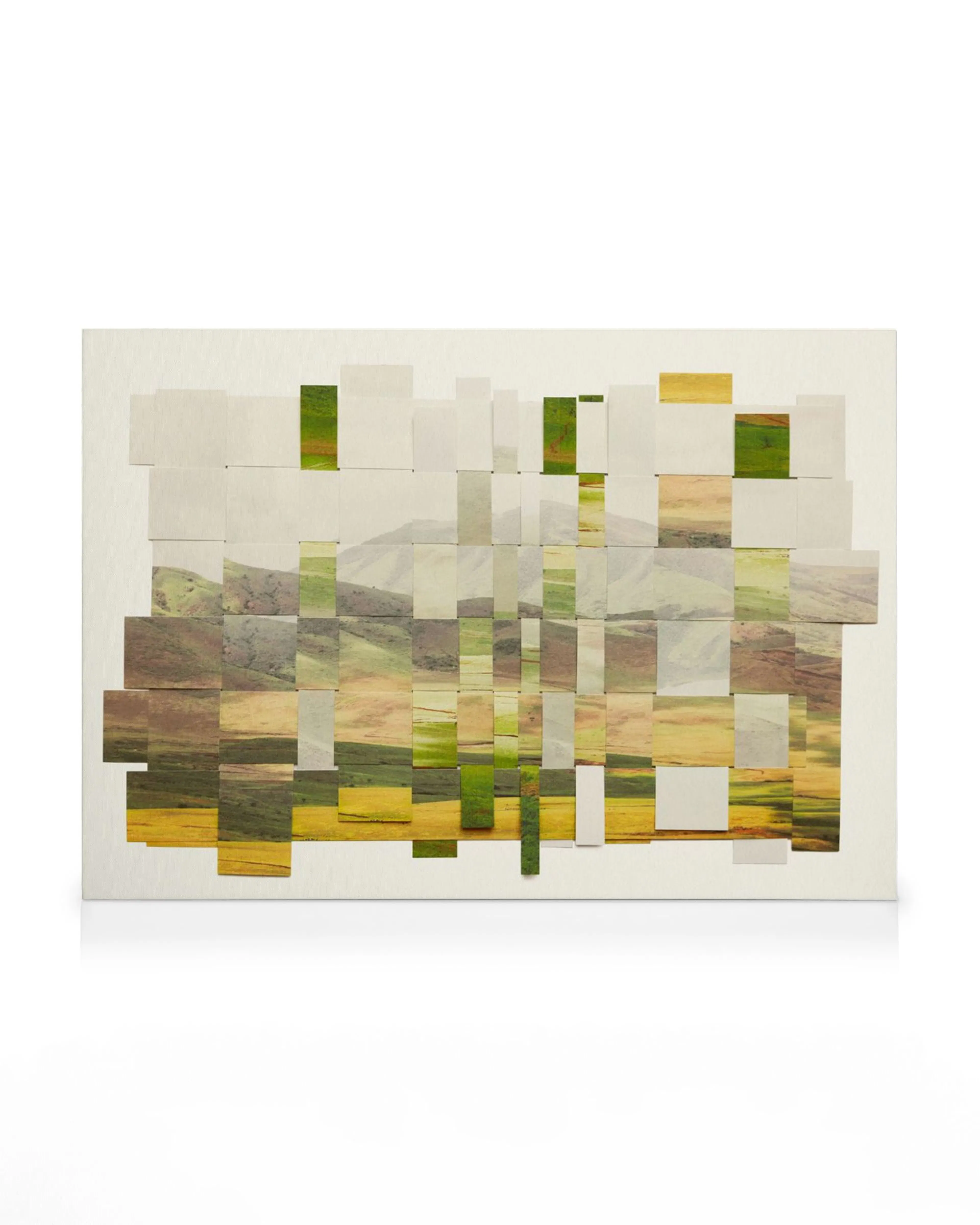 A canvas print featuring a landscape of hills and fields in green and gold tones, presented as a woven collage.