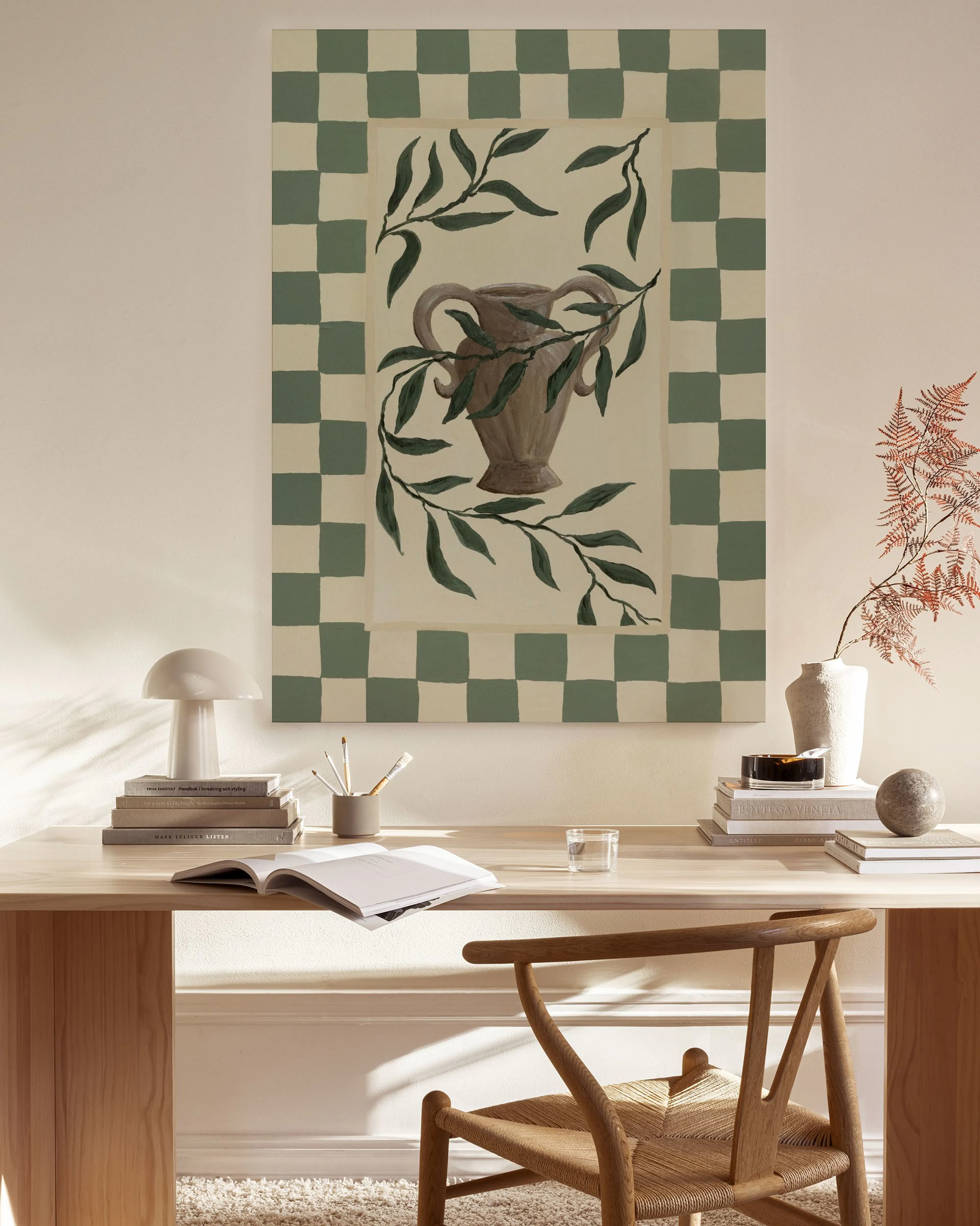 Leinwandbild mit grünem Schachbrettmuster, einer Amphore und Olivenzweigen, hängend in einem modernen Wohnzimmer.