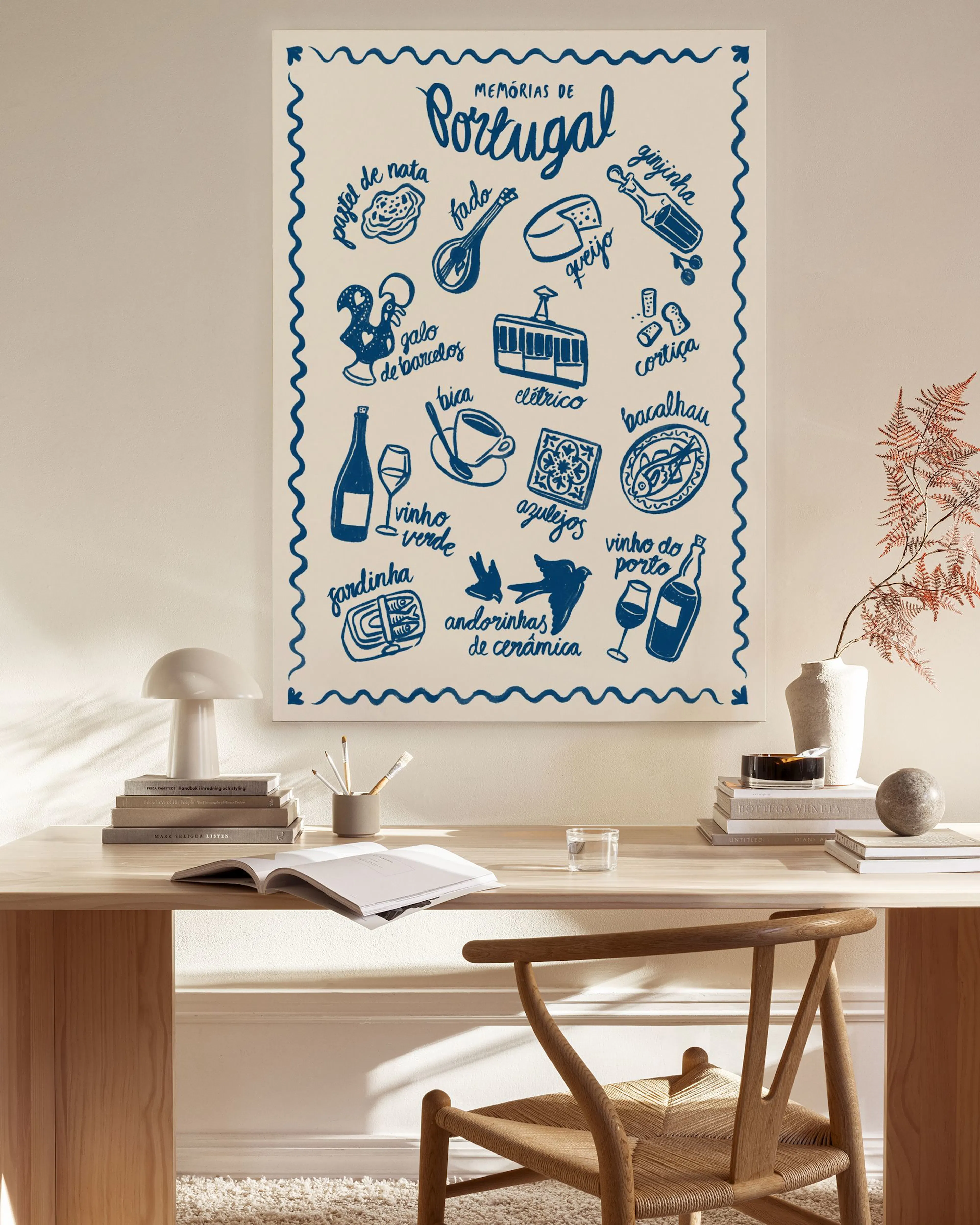 Tela decorativa com ilustrações azuis de símbolos portugueses sobre um fundo branco, pendurada numa sala de estar moderna.