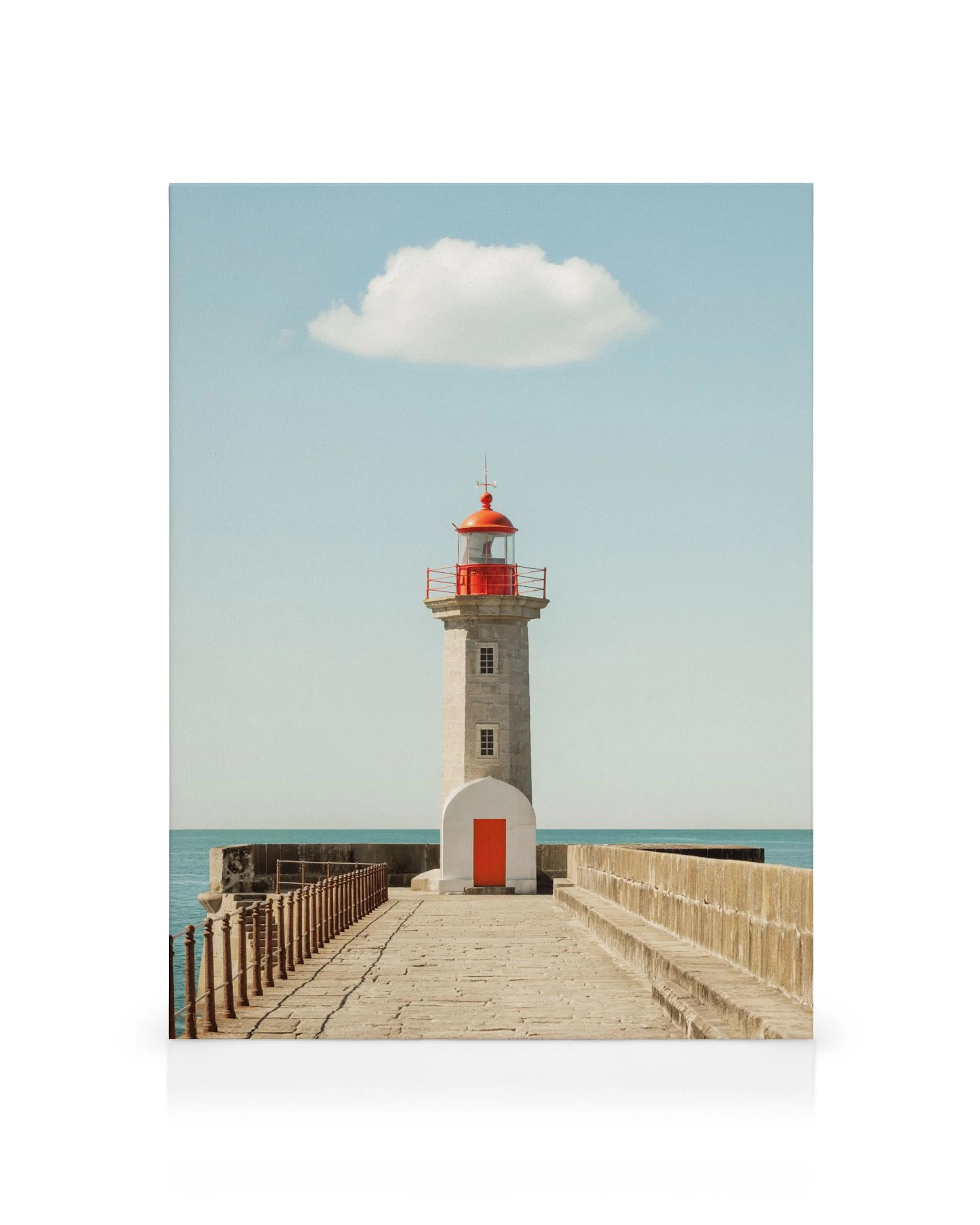 A canvas print of a white lighthouse with a red top and red door, under a blue sky with one cloud.
