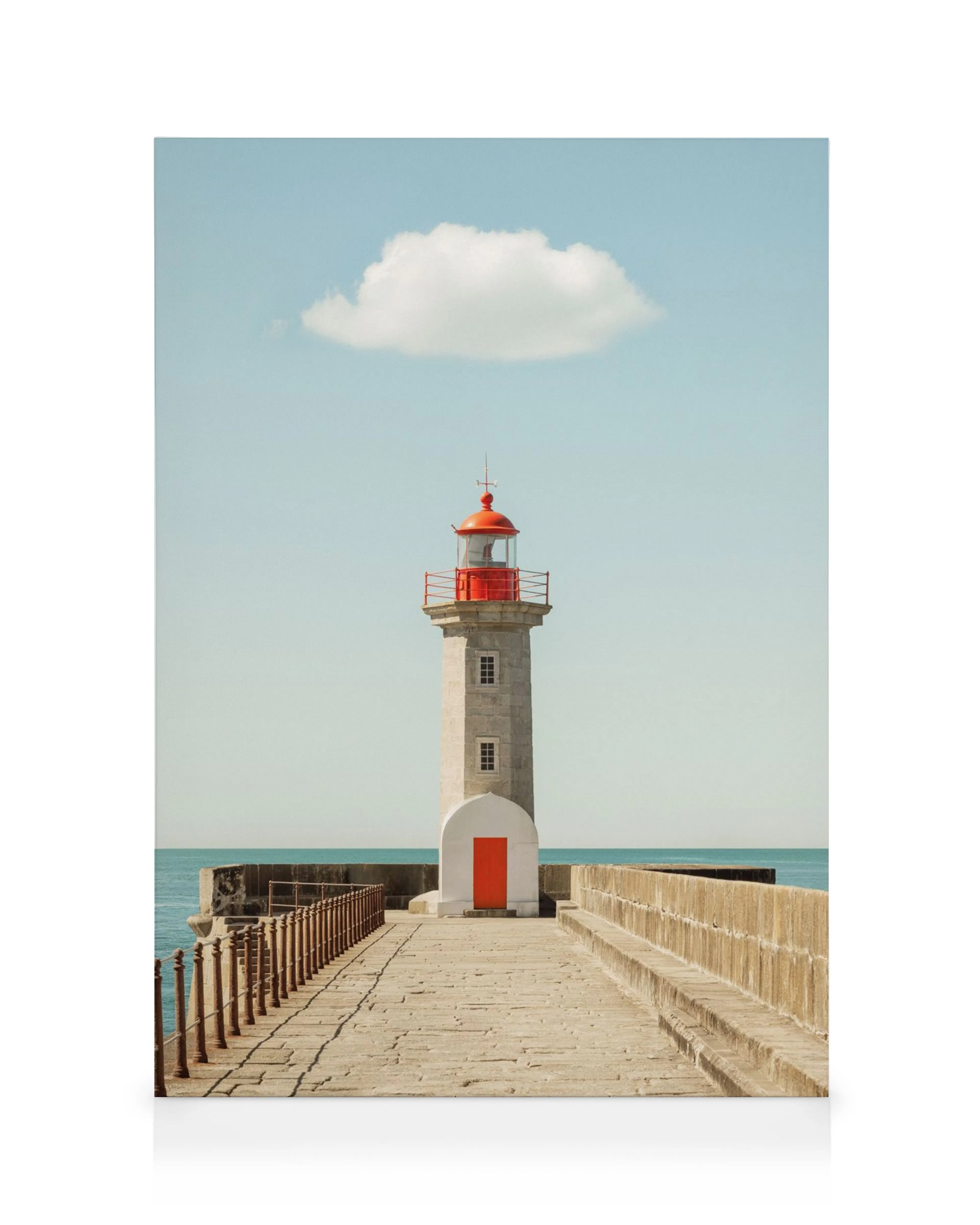 A canvas print featuring a grey lighthouse with a red top and door, under a blue sky with a single cloud.