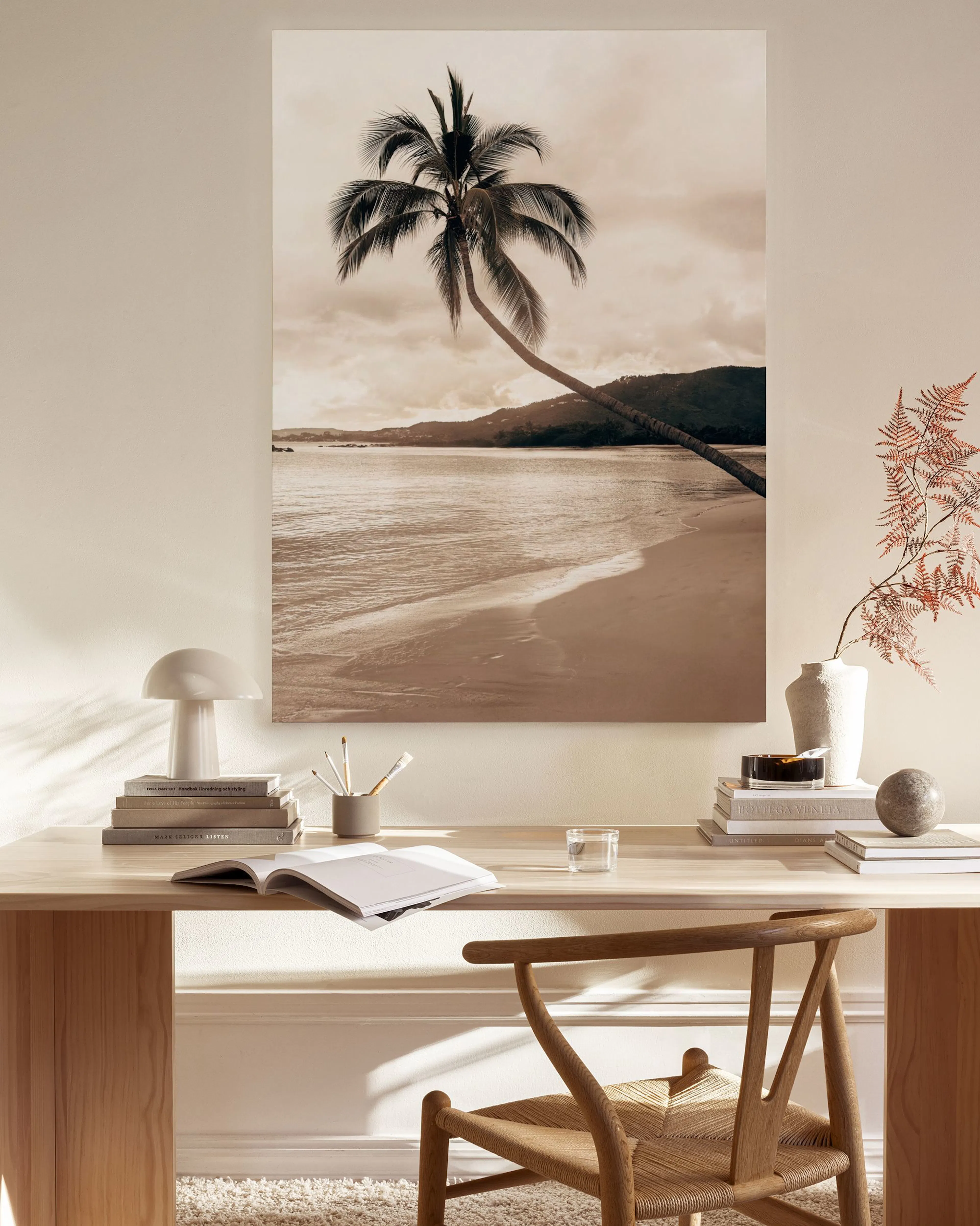 Leinwandbild einer Palme am Strand in Sepia-Tönen, über einem Holzmöbel im modernen Wohnzimmer.
