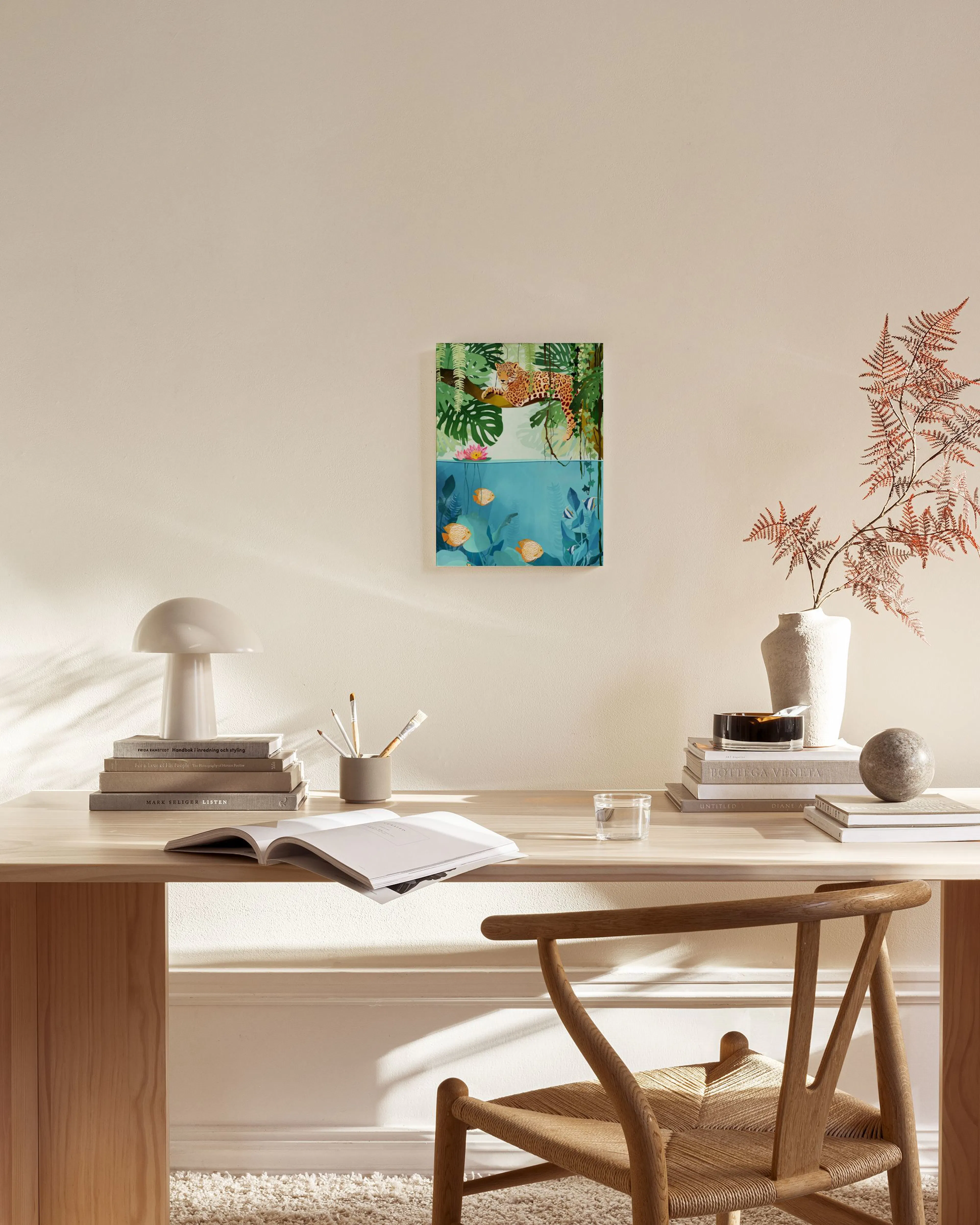 Canvas met luipaard in junglebladeren en goudvissen in water, hangend in een lichte woonkamer.