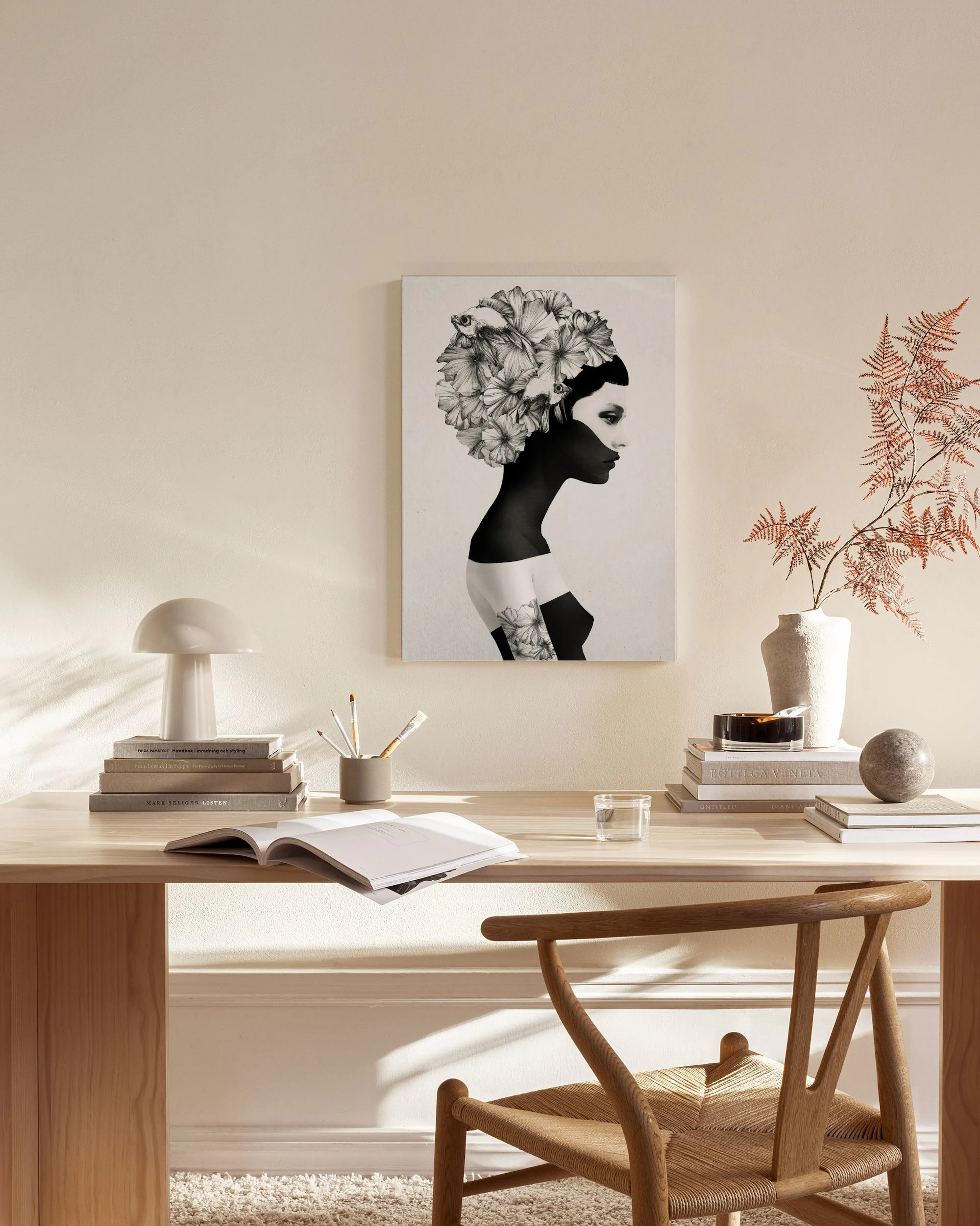 Canvas van een vrouw met donkere huid en een hoofd vol bloemen, hangend in een lichte woonkamer.