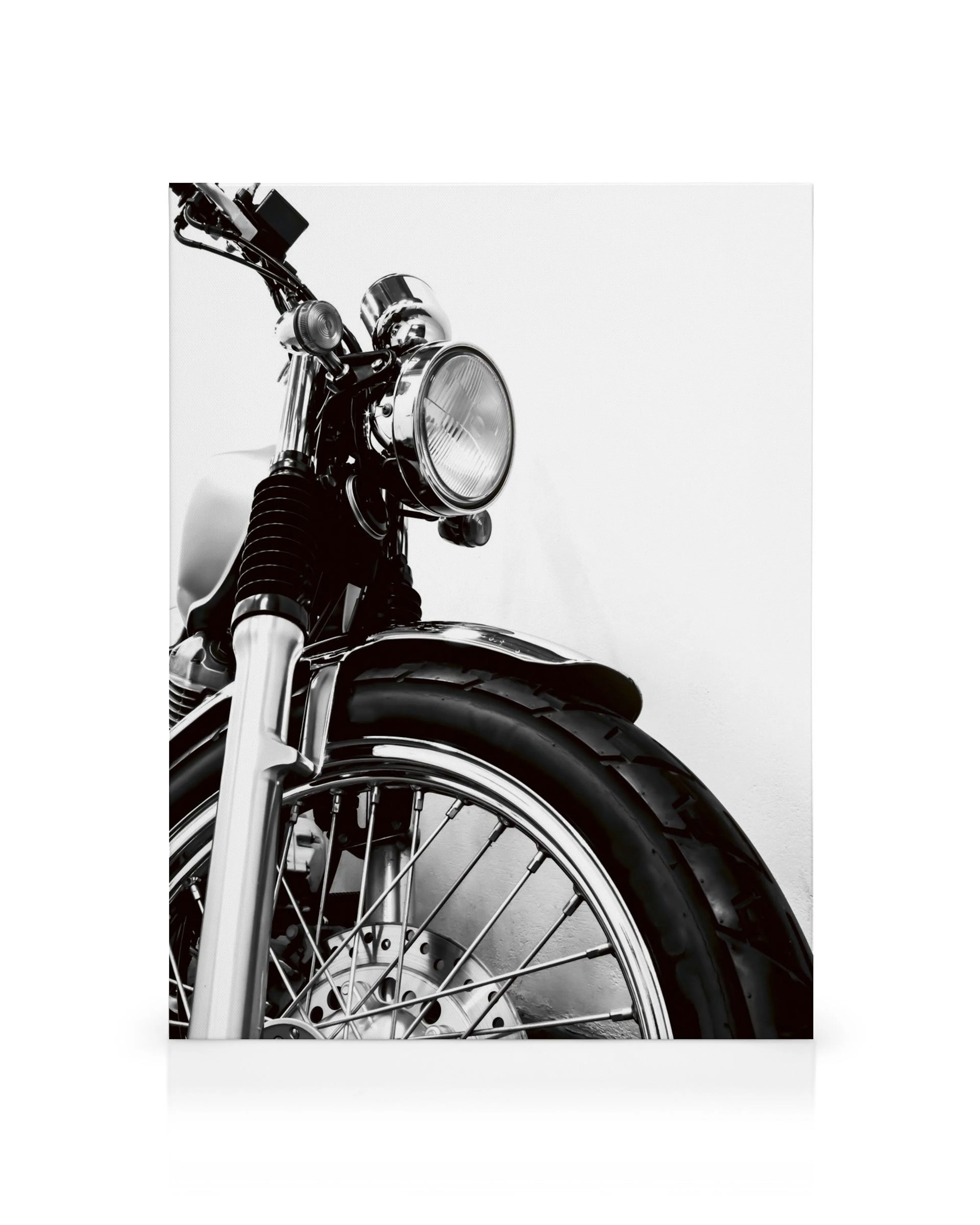 Zwart-wit close-up van een klassieke motorfiets met chromen details en een voorwiel, perfect voor motorliefhebbers.
