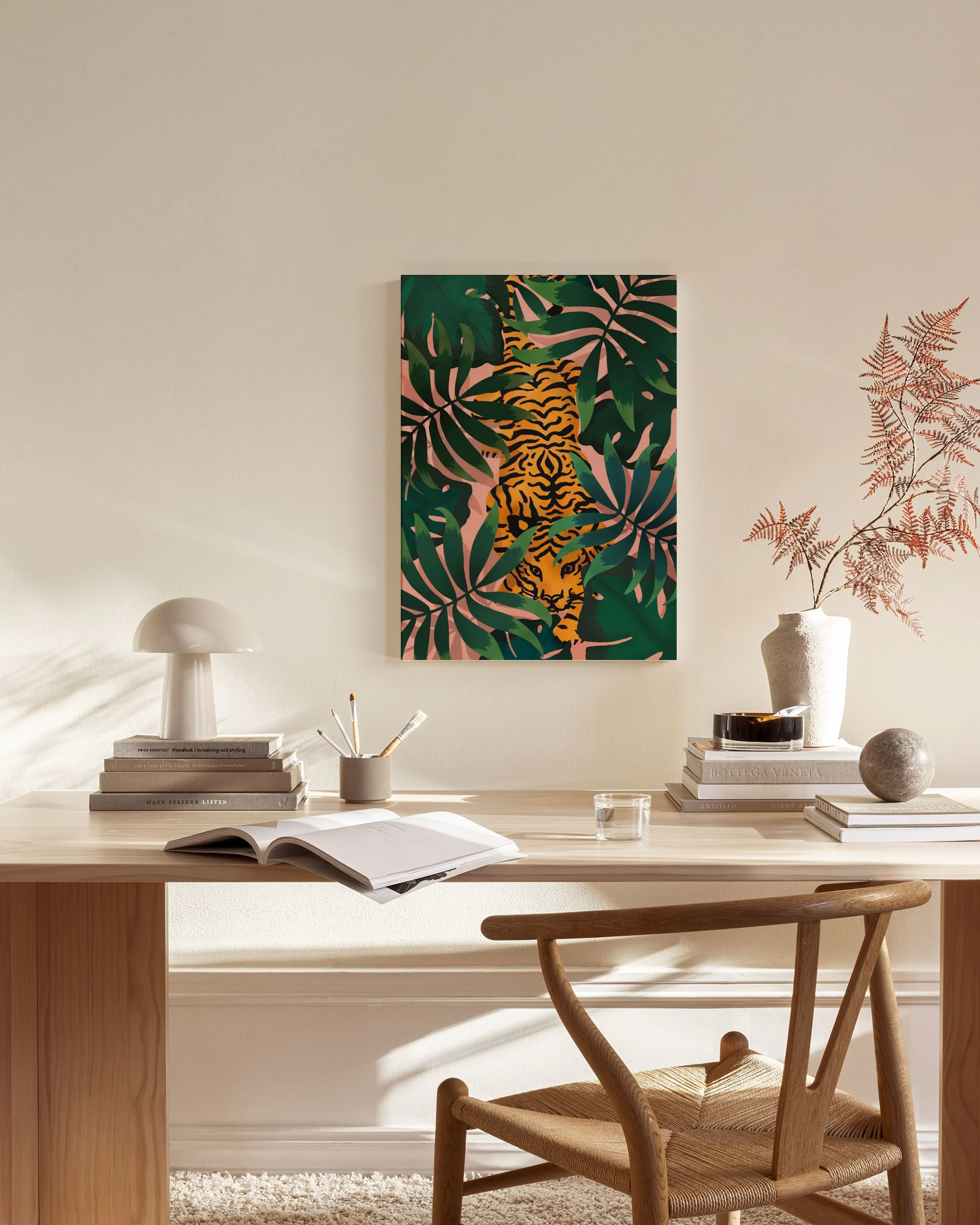 Toile murale décorative dun tigre orange et noir dans une jungle luxuriante sur fond rose, dans un salon moderne.