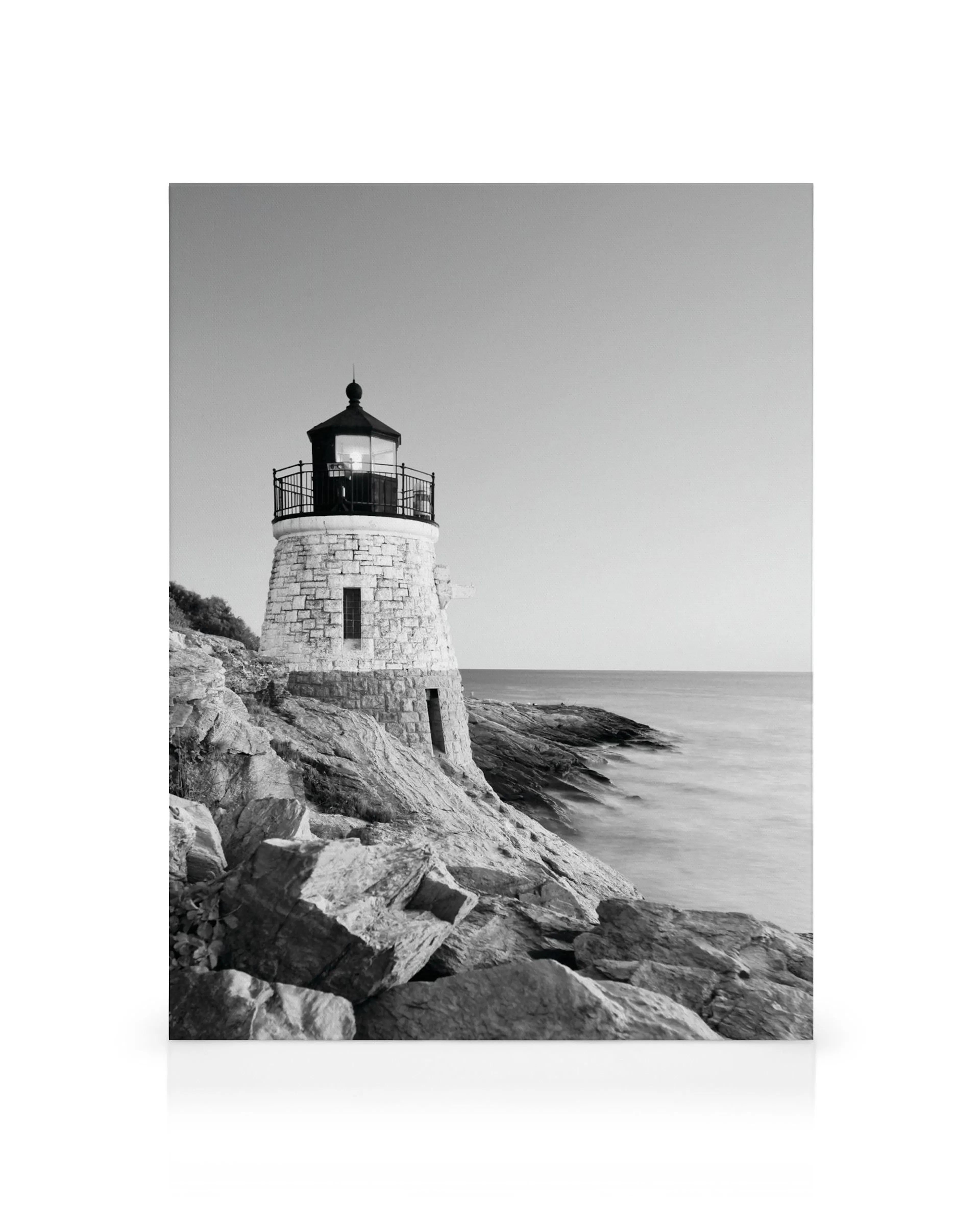 Schwarz-weißes Leuchtturm Leinwandbild auf felsiger Küste mit glattem Meer, ideal für eine maritime Wanddekoration.