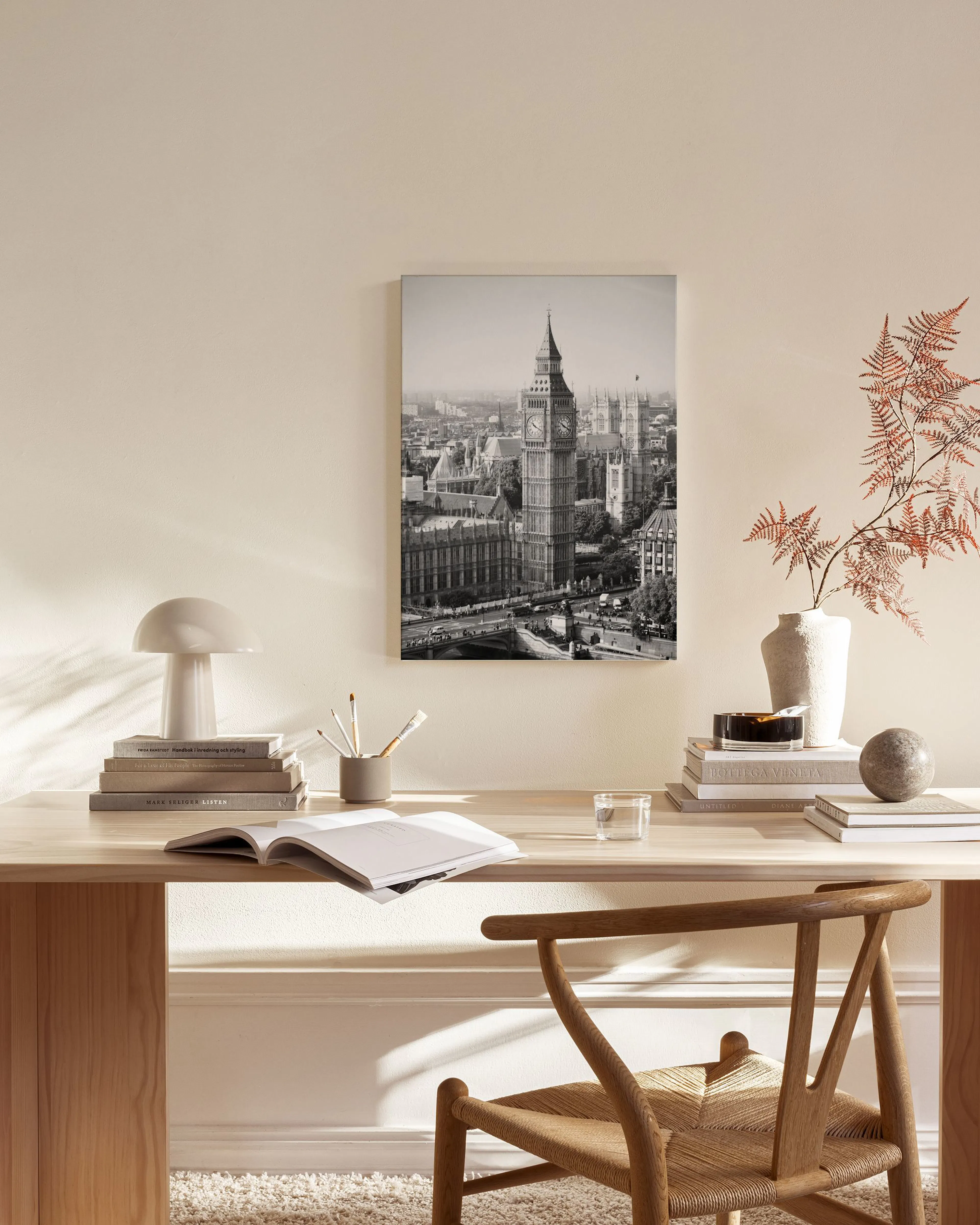 A black and white canvas print of Big Ben and the London cityscape, hanging in a modern living room above a wooden console table