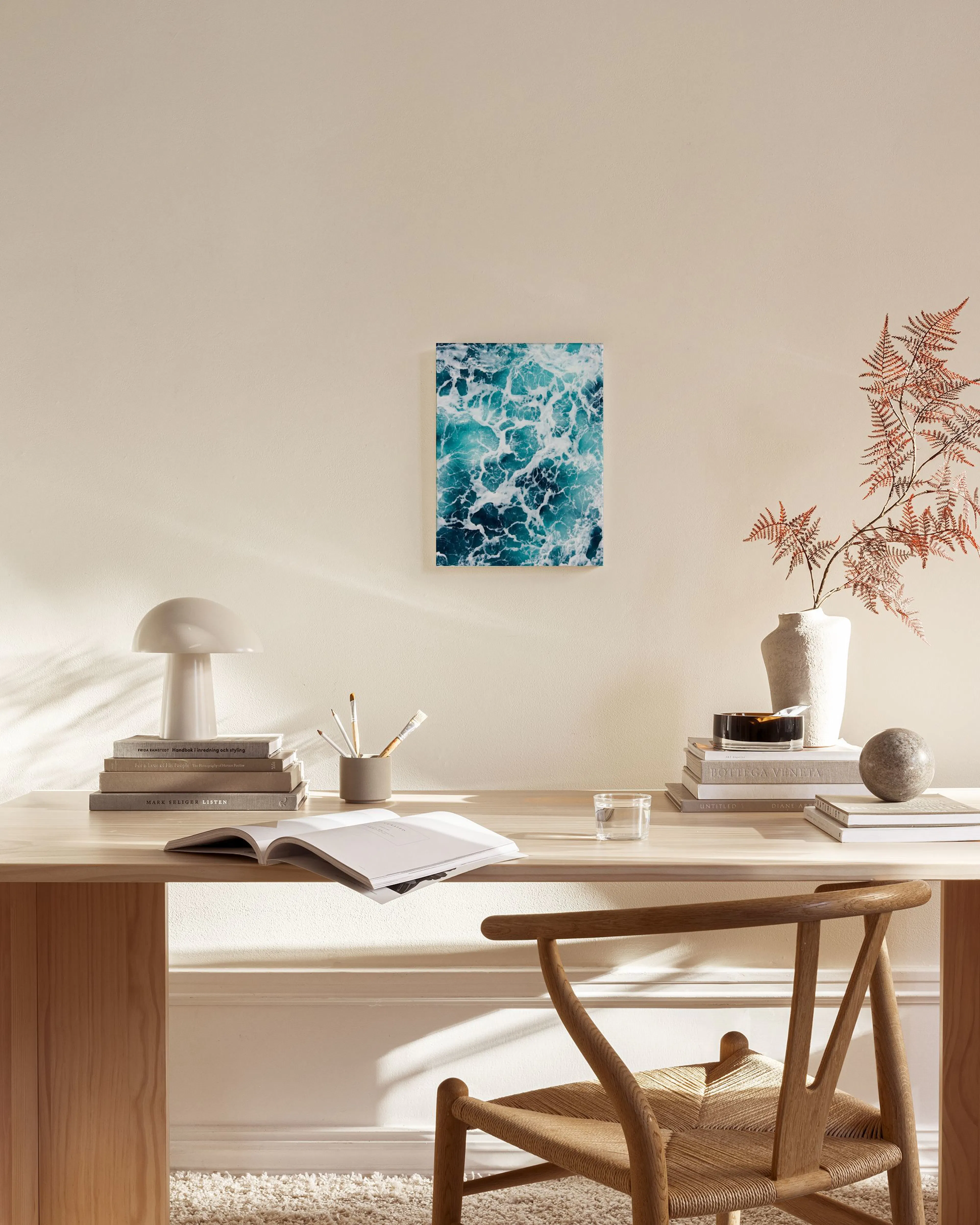 Leinwandbild mit tobendem, türkisblauem Meerwasser und weißen Schaumkronen, hängt in einem modernen Wohnzimmer über einem Sidebo