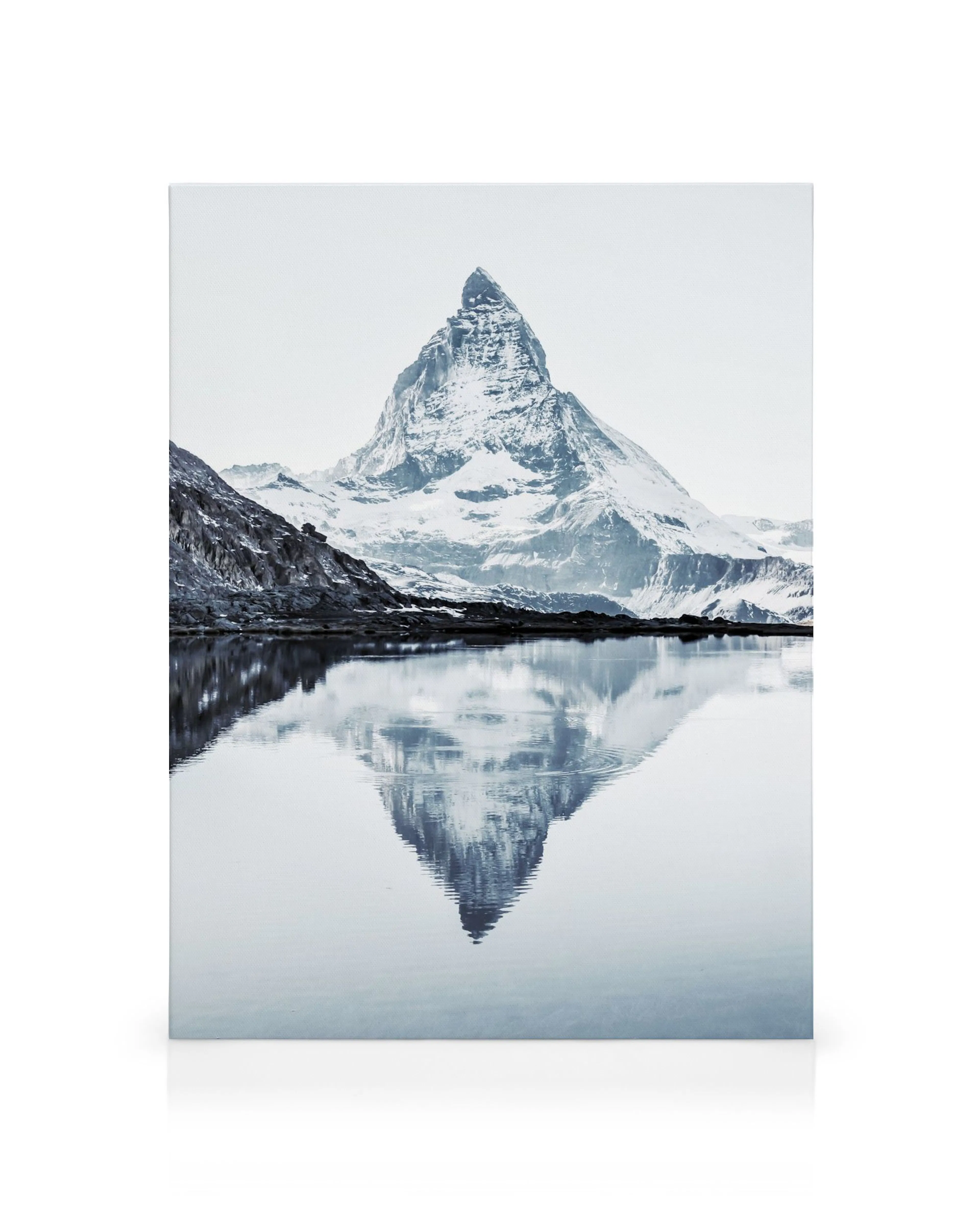 Snow-capped Matterhorn mountain reflected in calm blue water, scenic landscape canvas print.