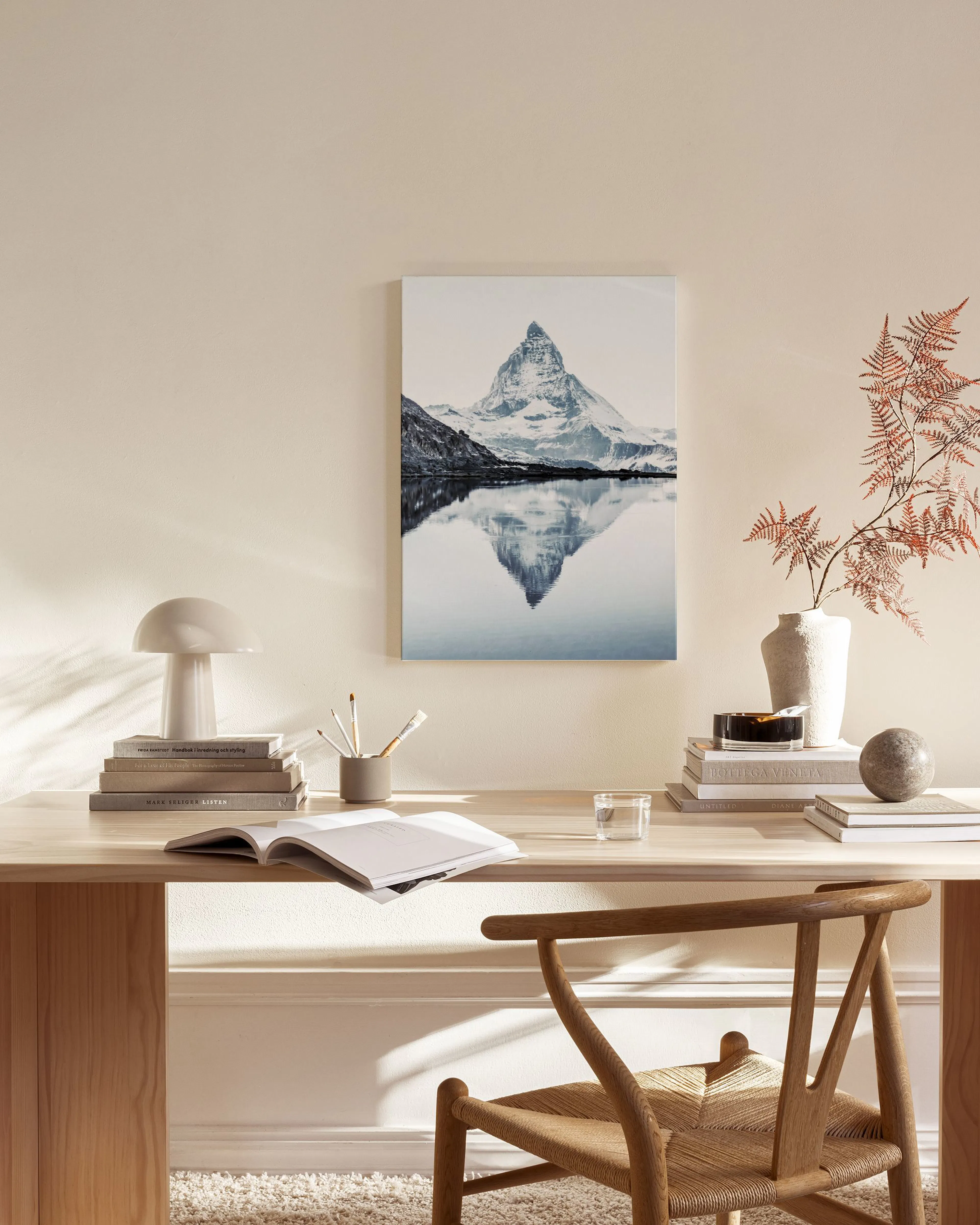 Canvas van de Matterhorn berg die reflecteert in een meer, hangend boven een houten dressoir in een woonkamer.