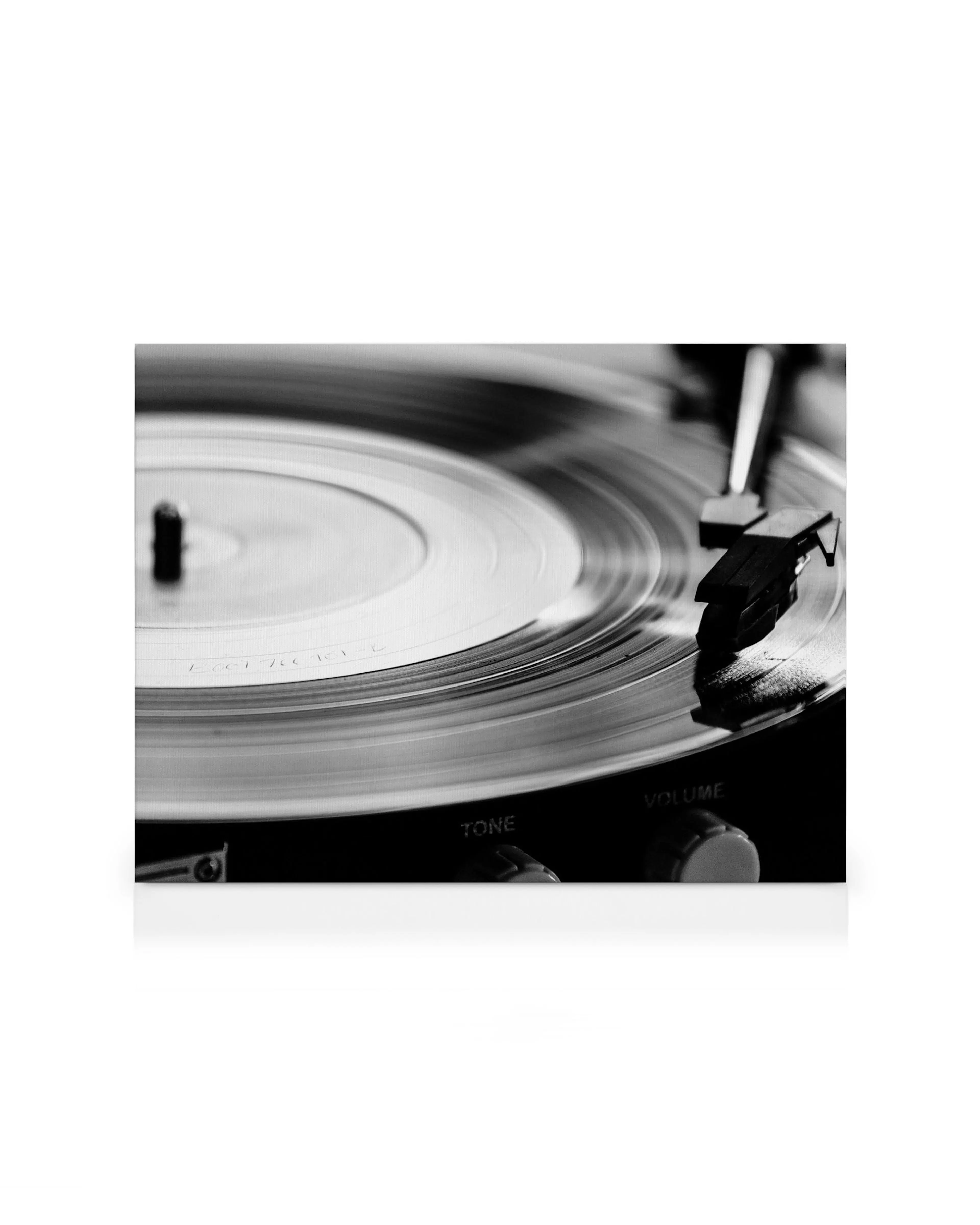 Toile noir et blanc dun disque vinyle tournant sur une platine, avec les boutons Tone et Volume visibles