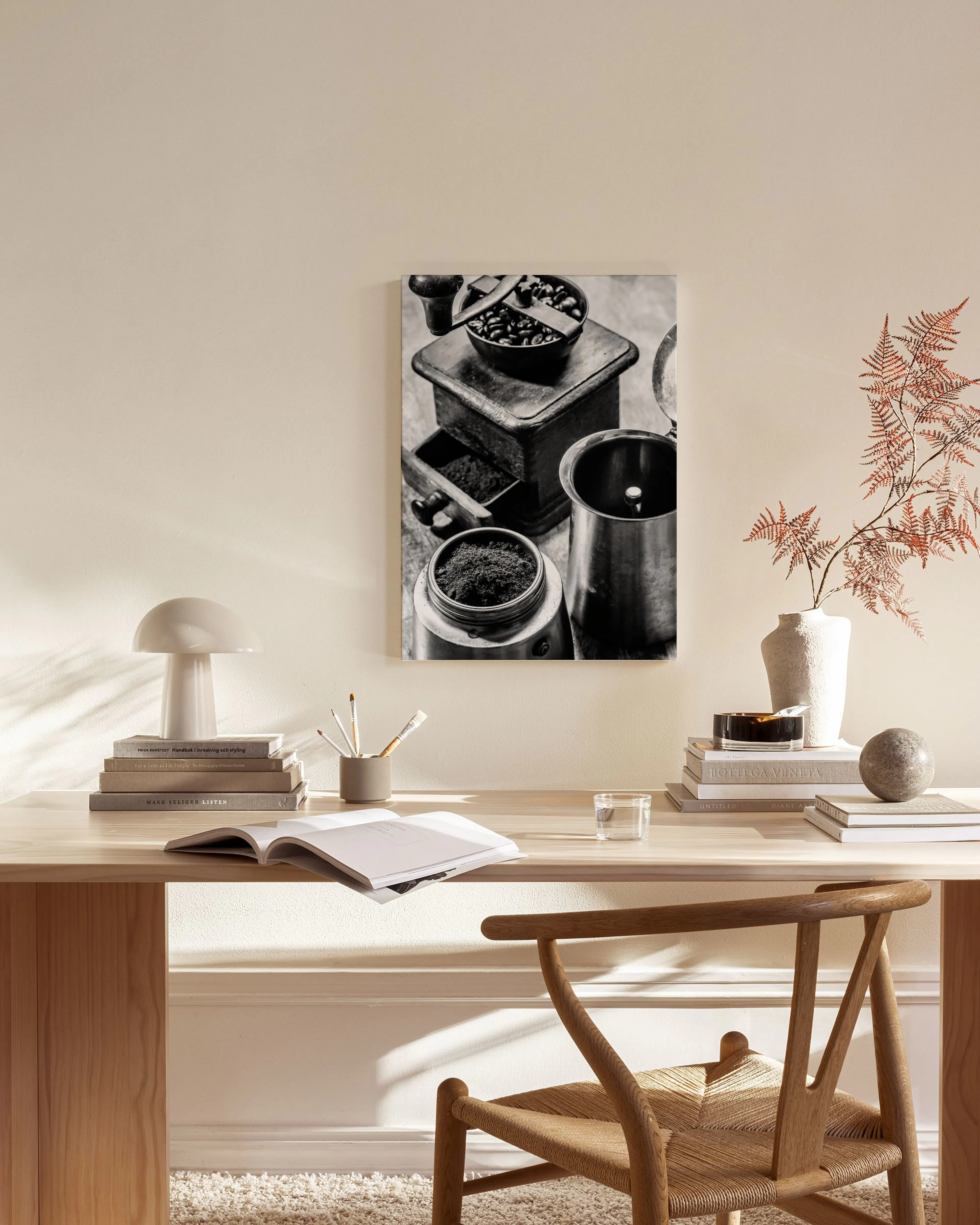 Toile noir et blanc dun moulin à café et de grains, accrochée au-dessus dun banc en bois dans un salon moderne.