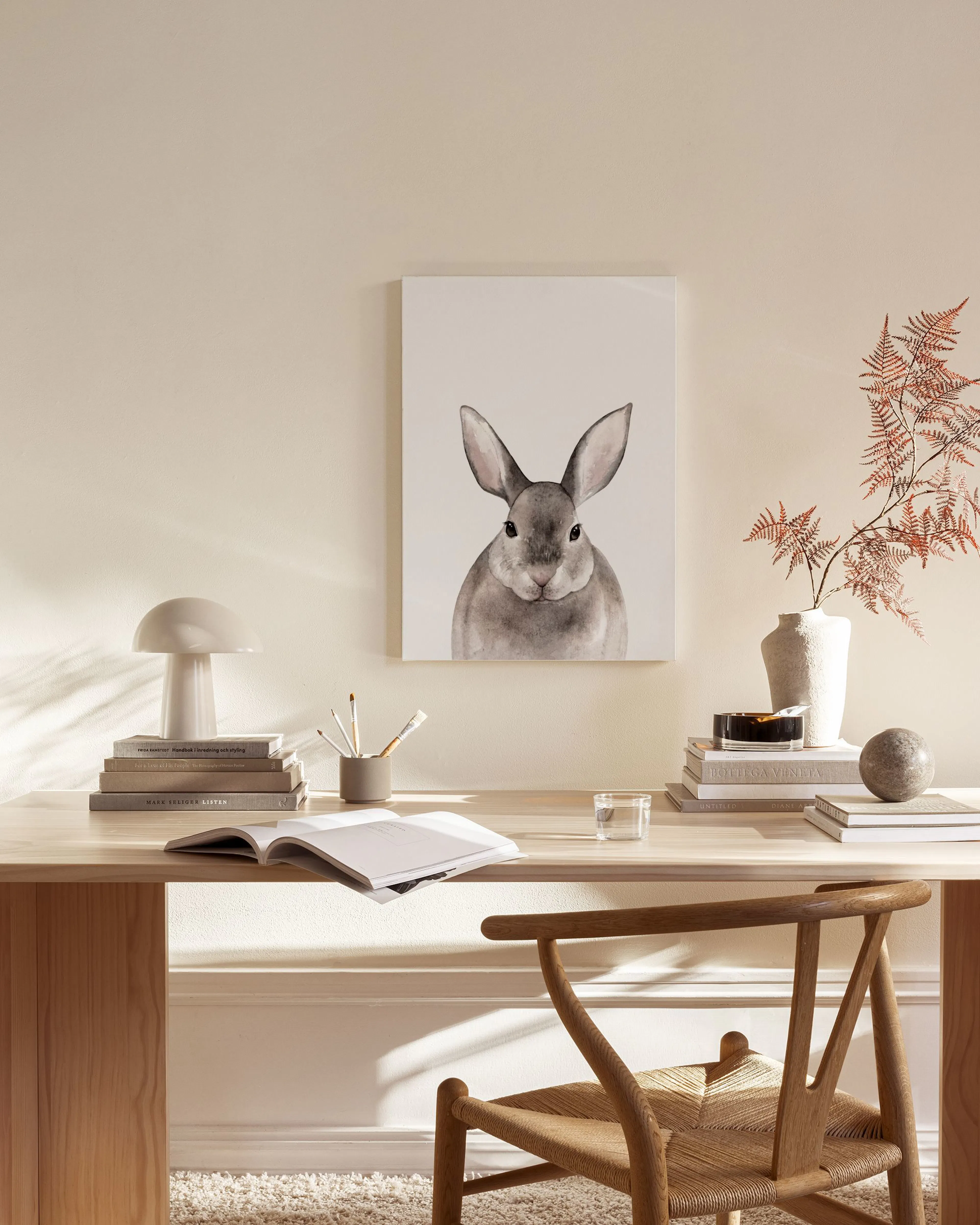 Leinwandbild mit einem grauen Kaninchen-Kopf in einem modernen Wohnzimmer über einem Sideboard.