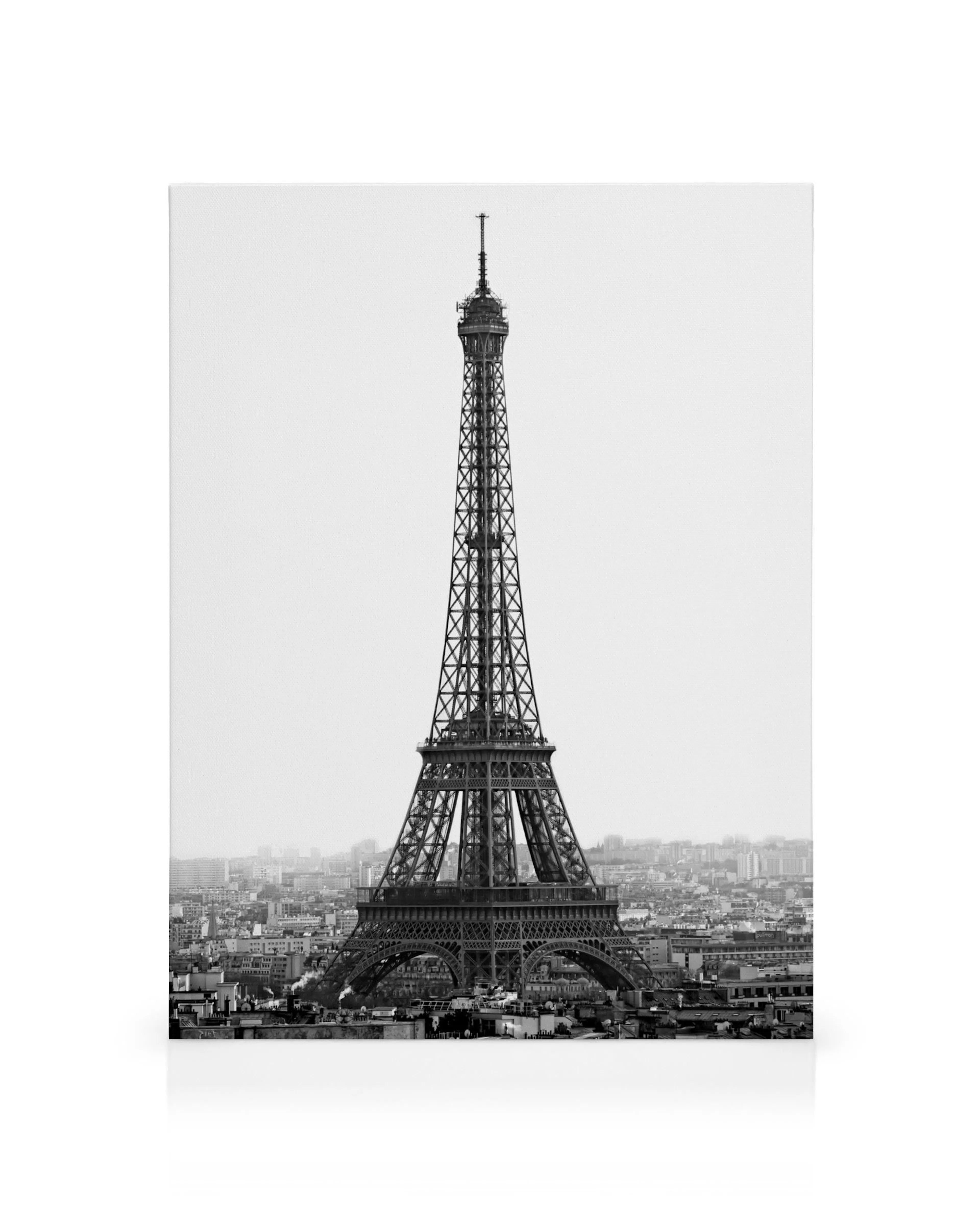 Sort/hvid lærredstryk af Eiffeltårnet i Paris, der rager op over bybilledet, et ikonisk vartegn.