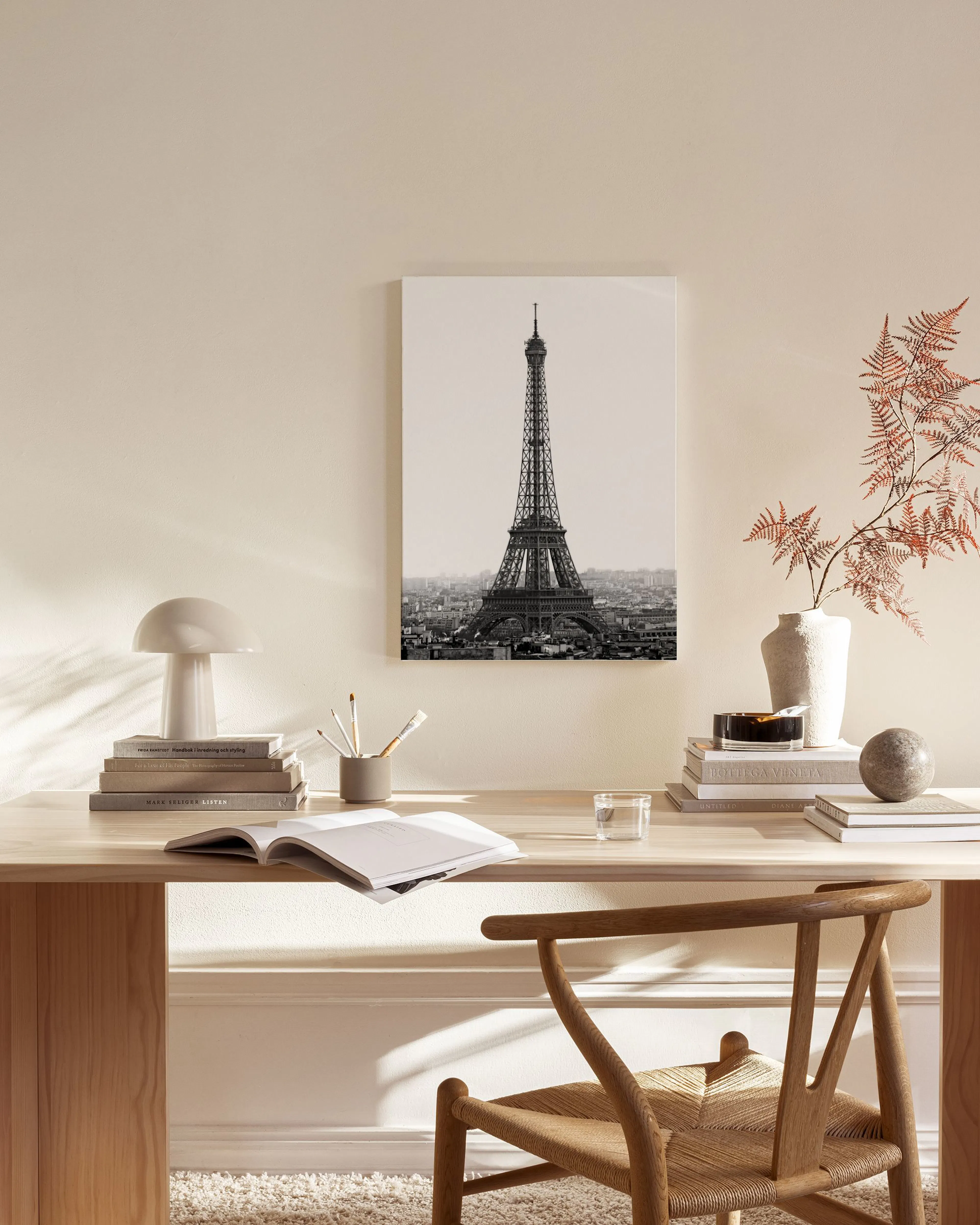 Lienzo de la Torre Eiffel en blanco y negro, colgado en una sala de estar moderna con muebles de madera clara.