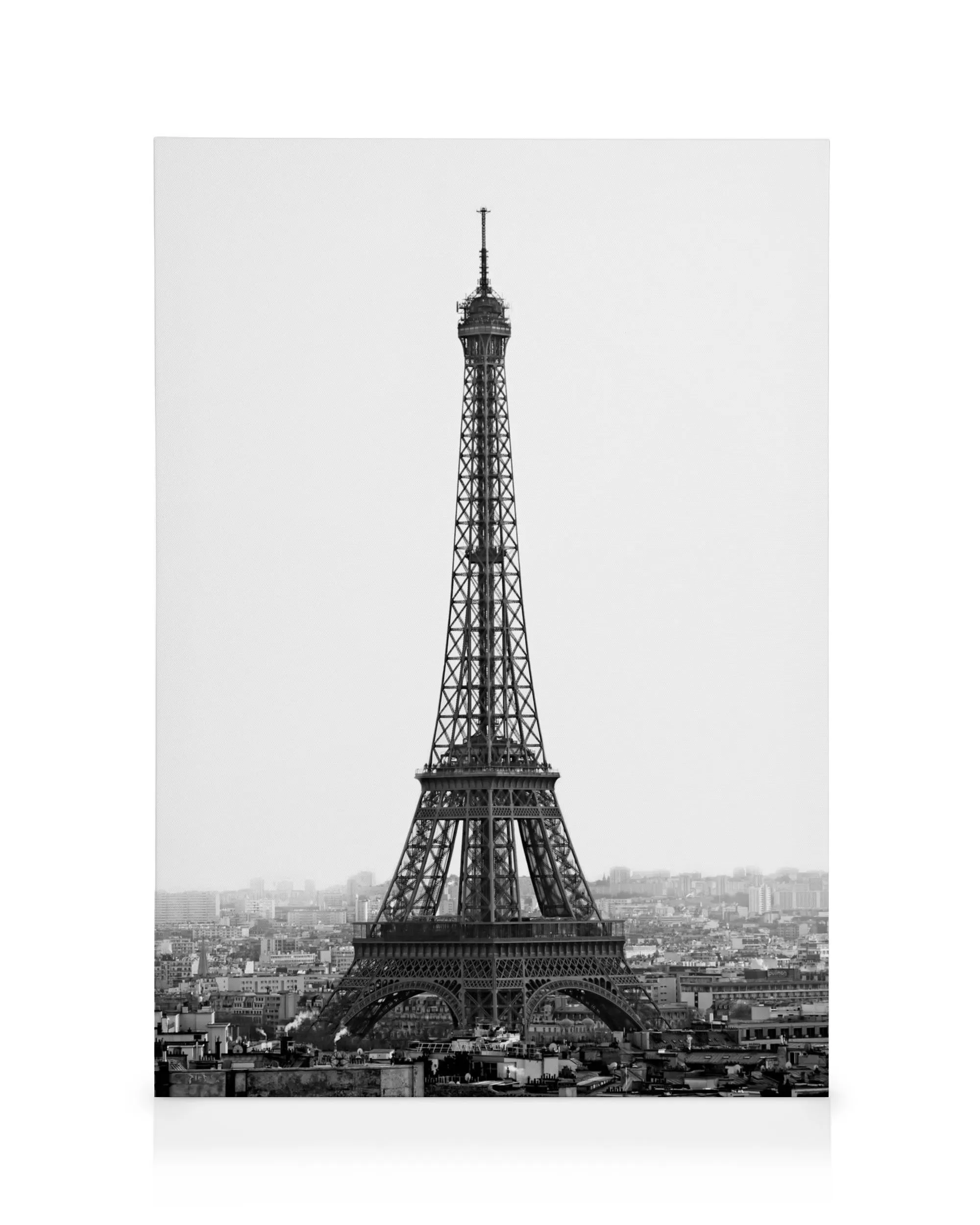 Schwarz-weißes Leinwandbild des Eiffelturms in Paris, der über der Stadt thront.