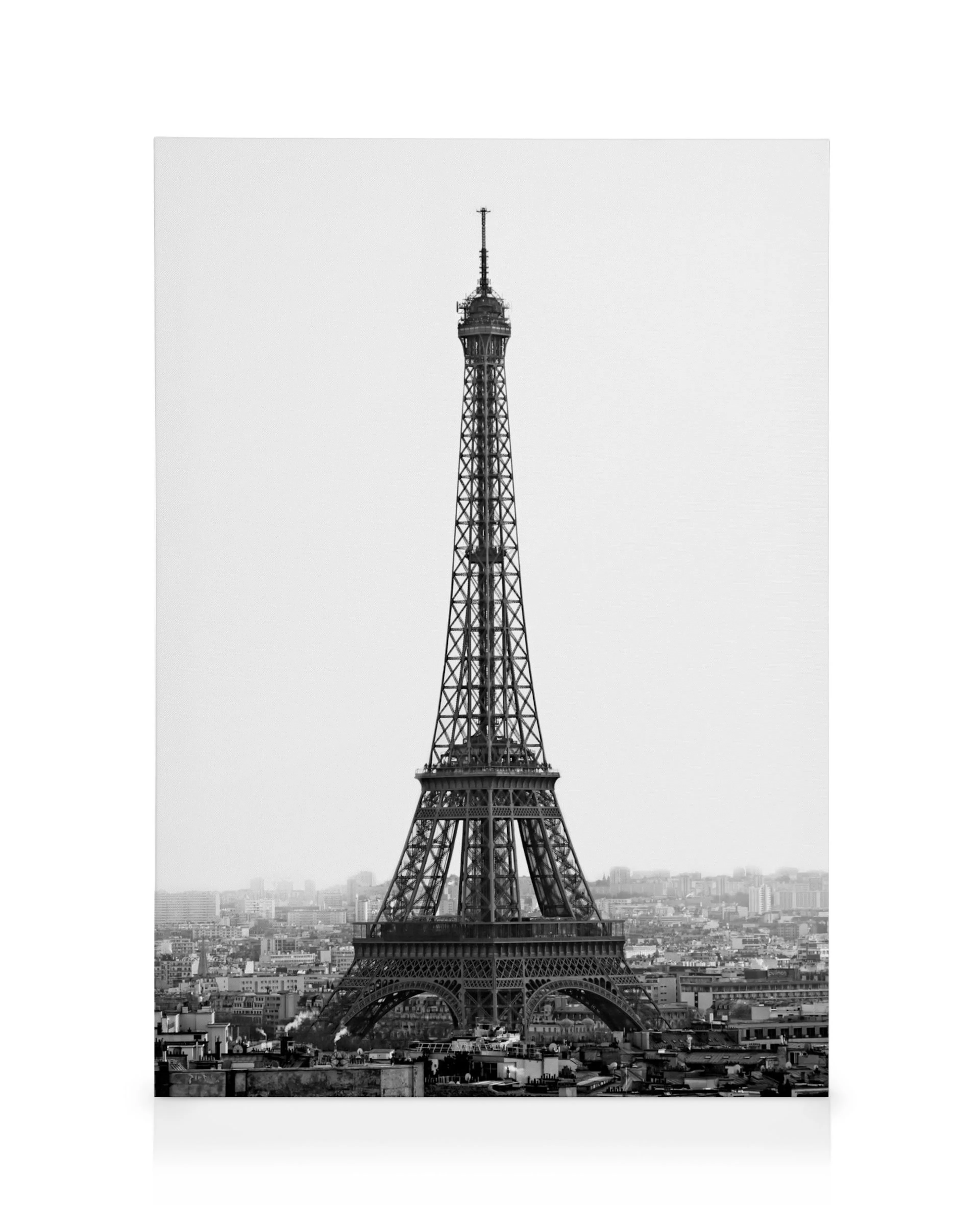 Schwarz-weißes Leinwandbild des Eiffelturms in Paris, der über der Stadt thront.