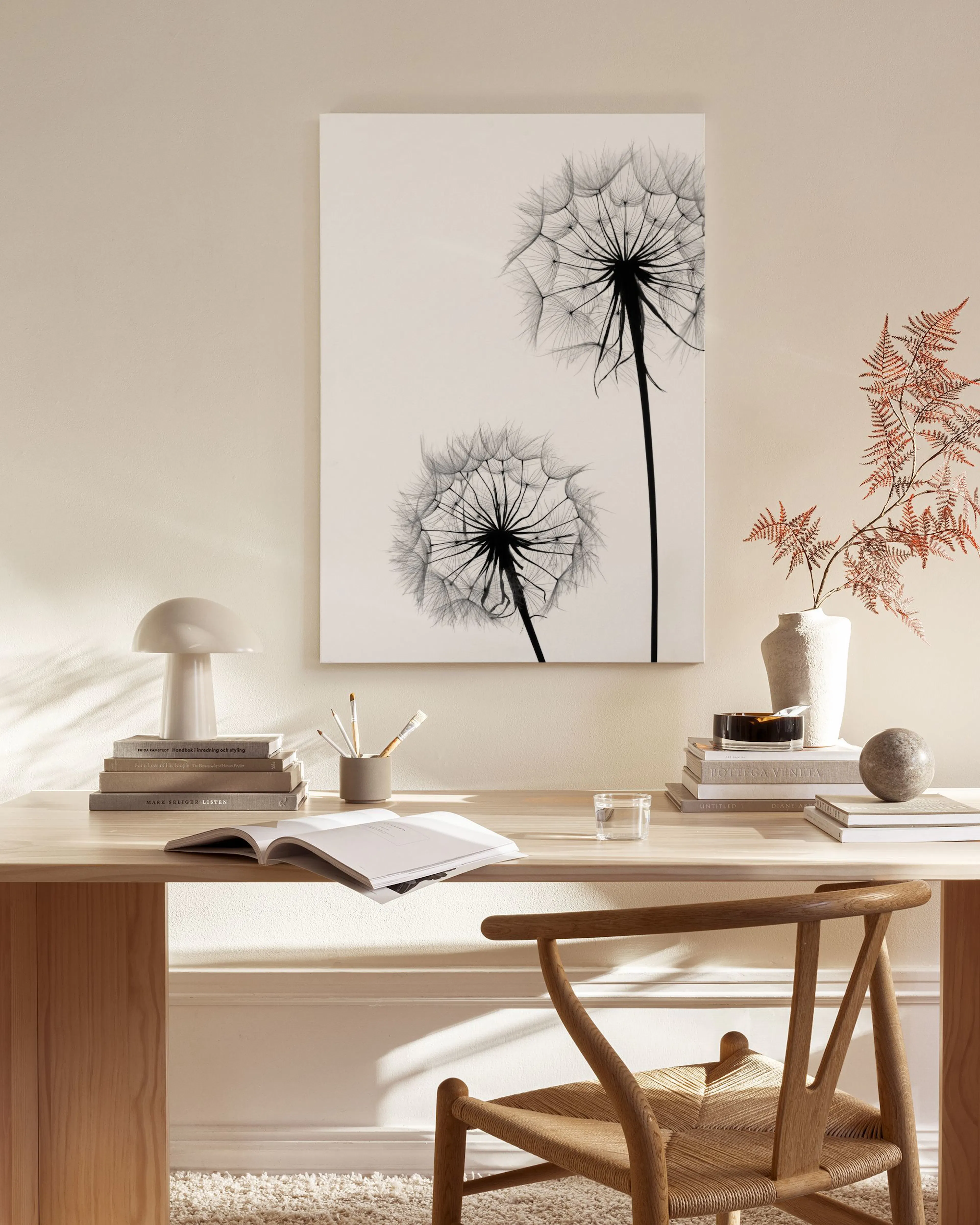 Schwarz-weisses Leinwandbild mit zwei Pusteblumen, hängend über einem Sideboard im modernen Wohnzimmer.