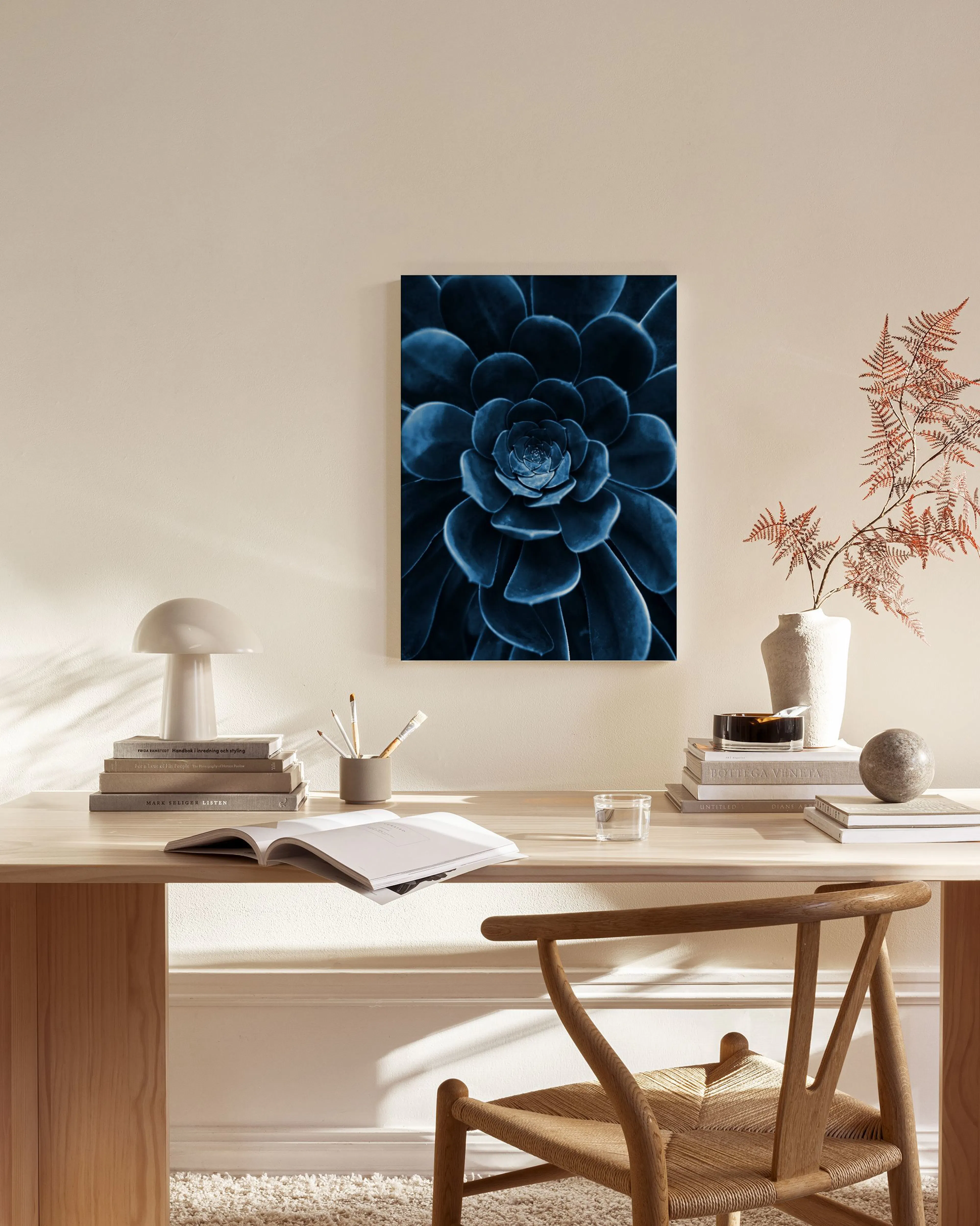 Toile de plante succulente bleu foncé, affichée dans un salon moderne au-dessus dun meuble en bois clair.