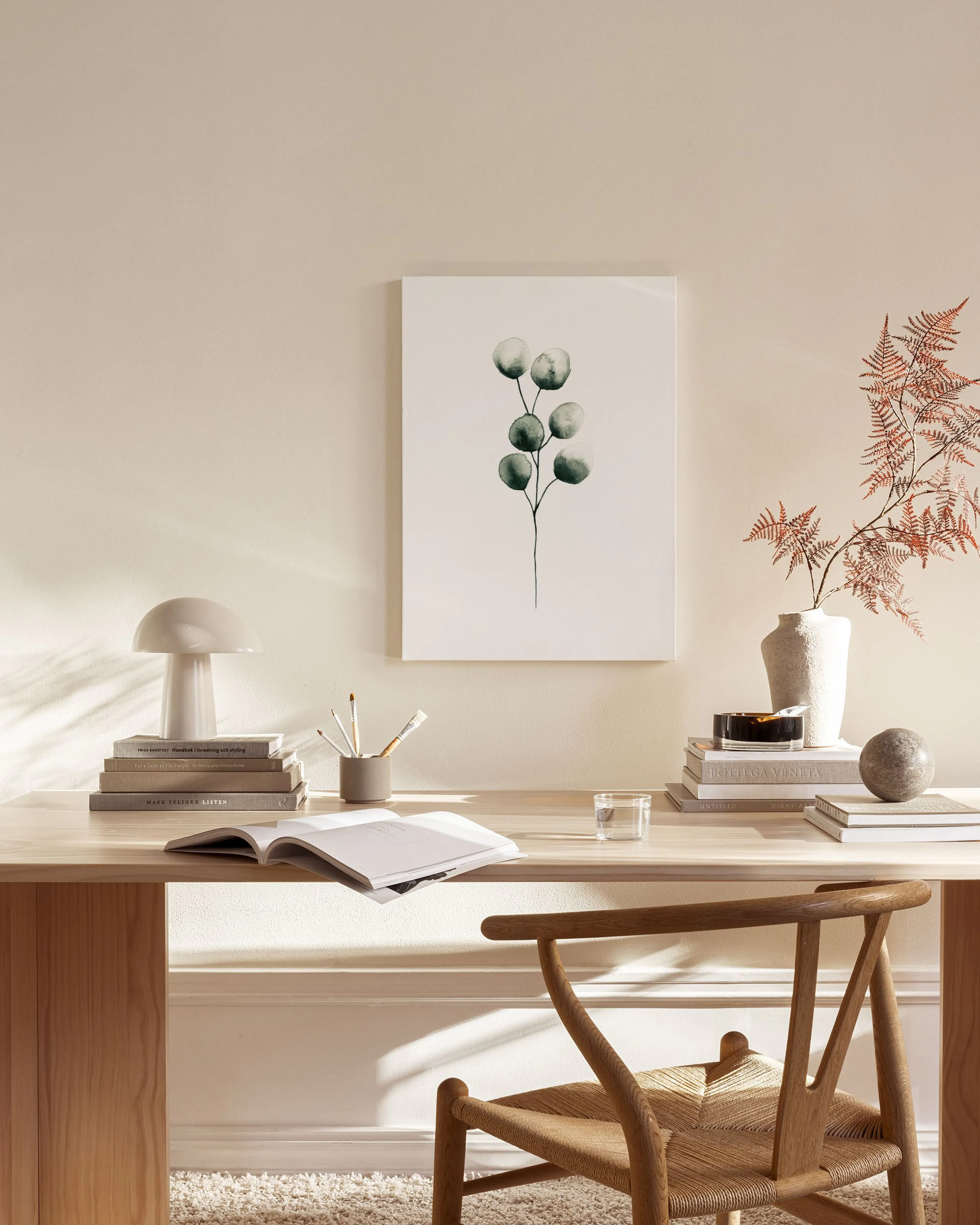 Canvas met een minimalistische aquarel van een eucalyptus tak, hangend in een lichte woonkamer.