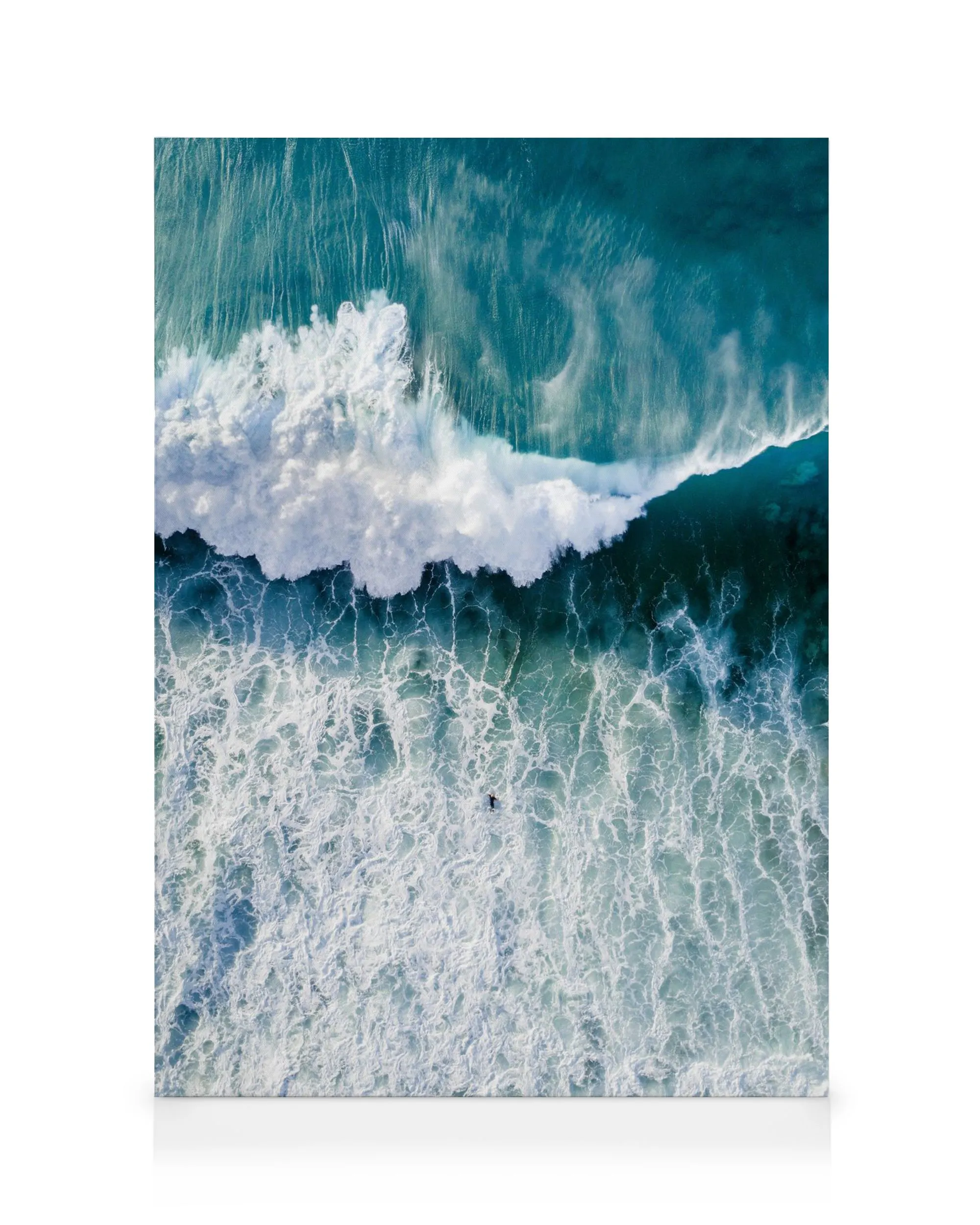 Aerial view of a deep blue ocean wave with white foam, a solitary swimmer, on a canvas print. Surfers wave art.