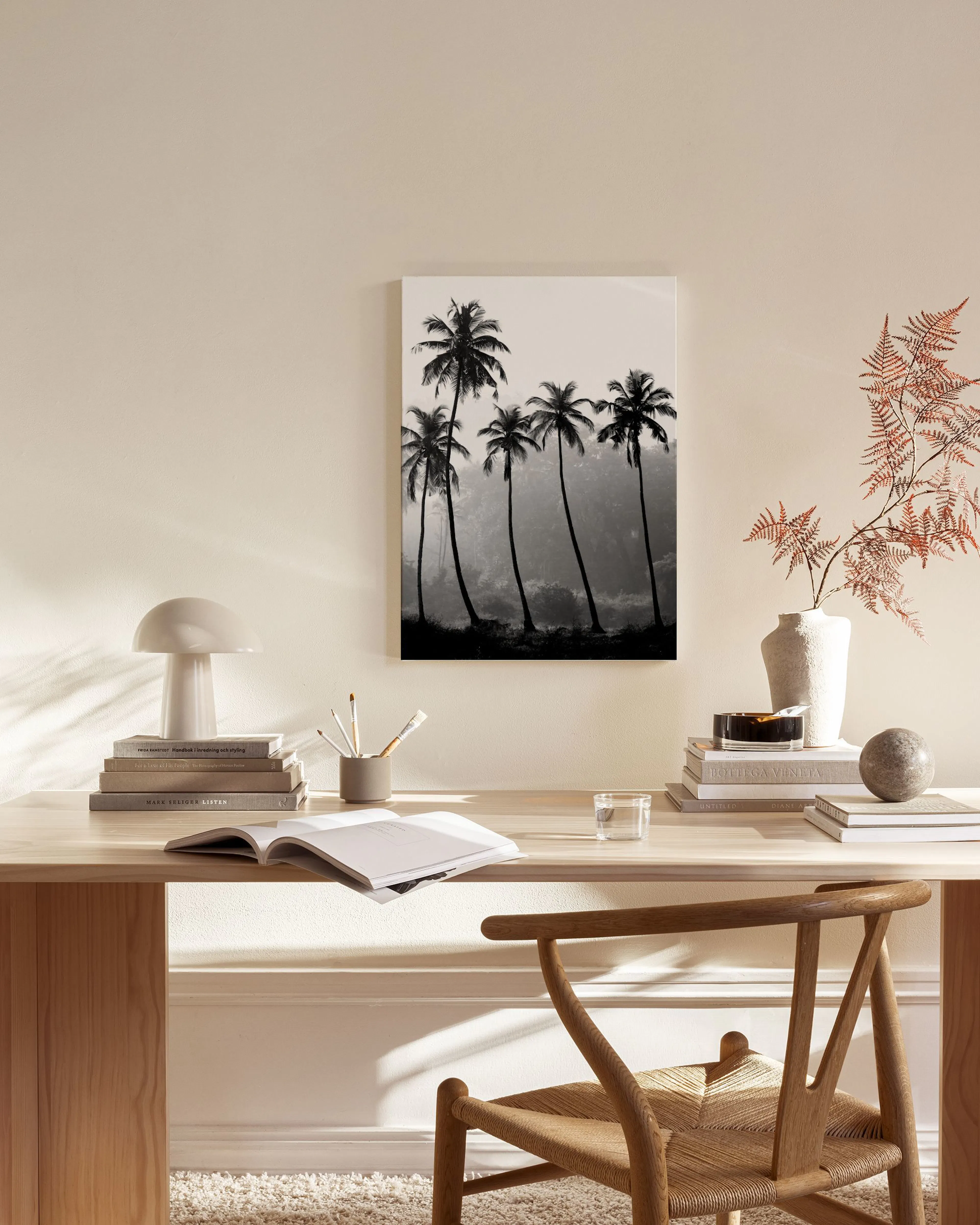 Zwart-wit canvas van palmbomen silhouetten tegen een lichte mistige hemel, hangend in een neutrale woonkamer.