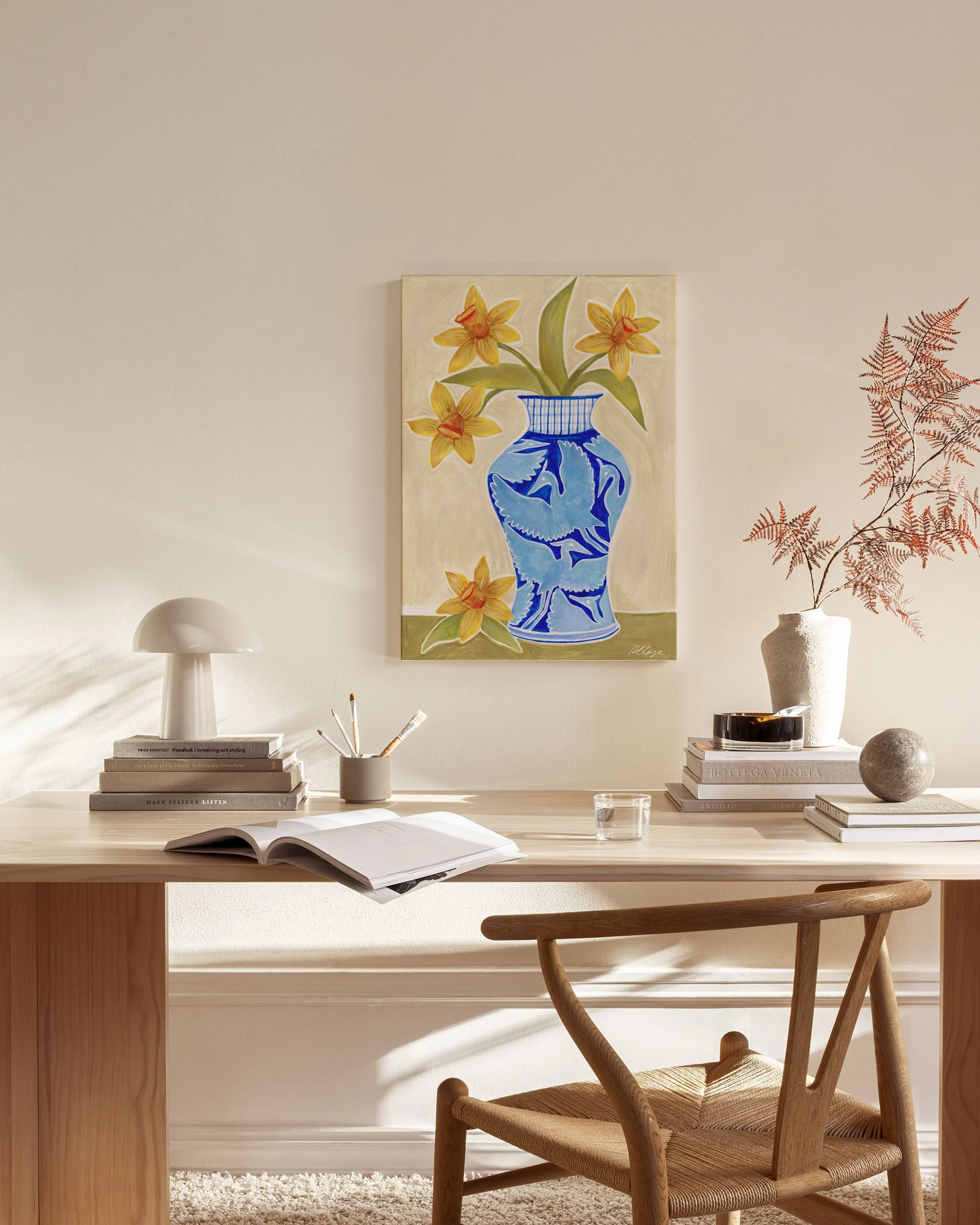 Leinwandbild mit gelben Narzissen in blauer Vase, hängt über einem Sideboard im Wohnzimmer.