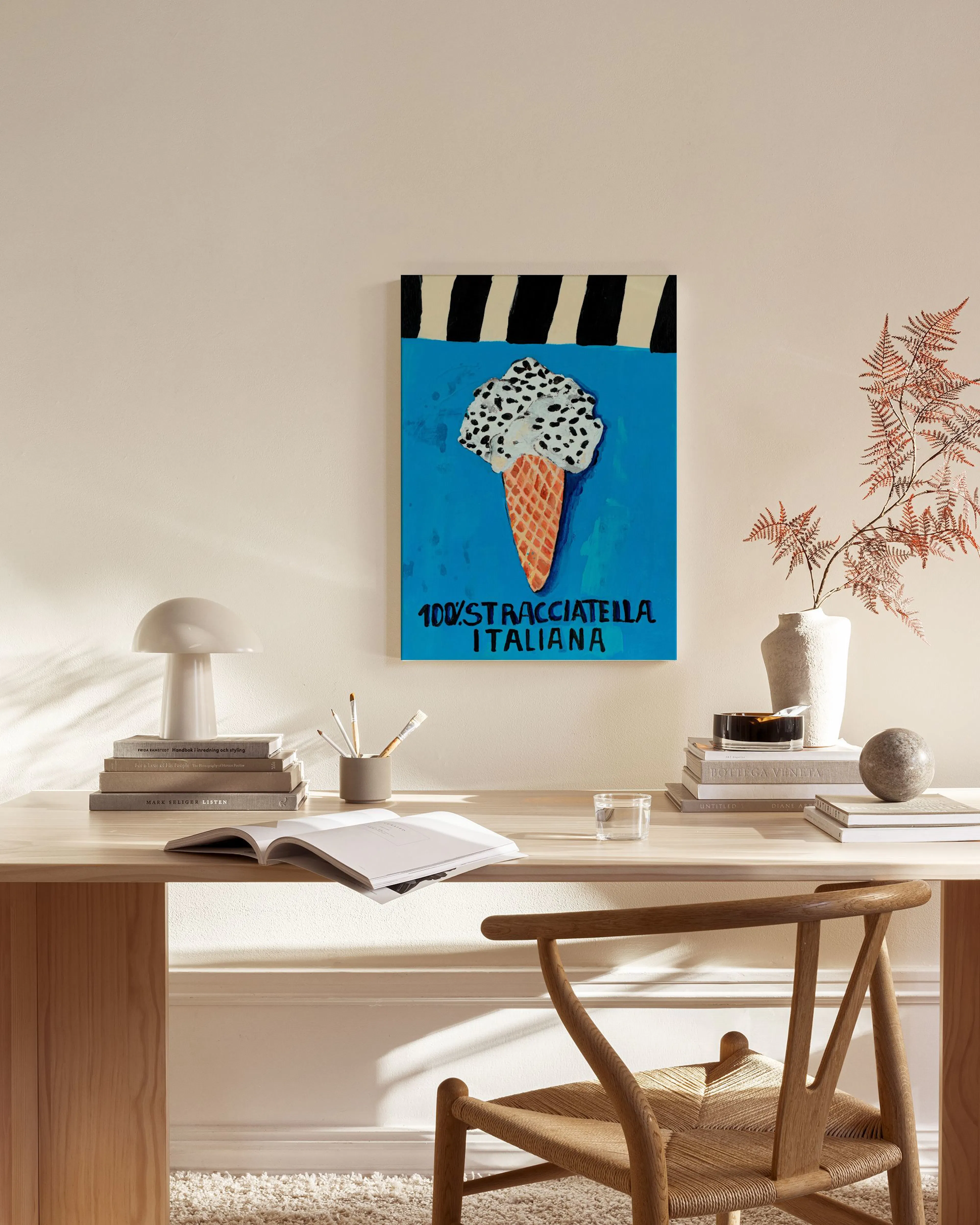 Canvastavla med illustration av en stracciatella-glass på blå bakgrund, hängande i ett modernt vardagsrum.
