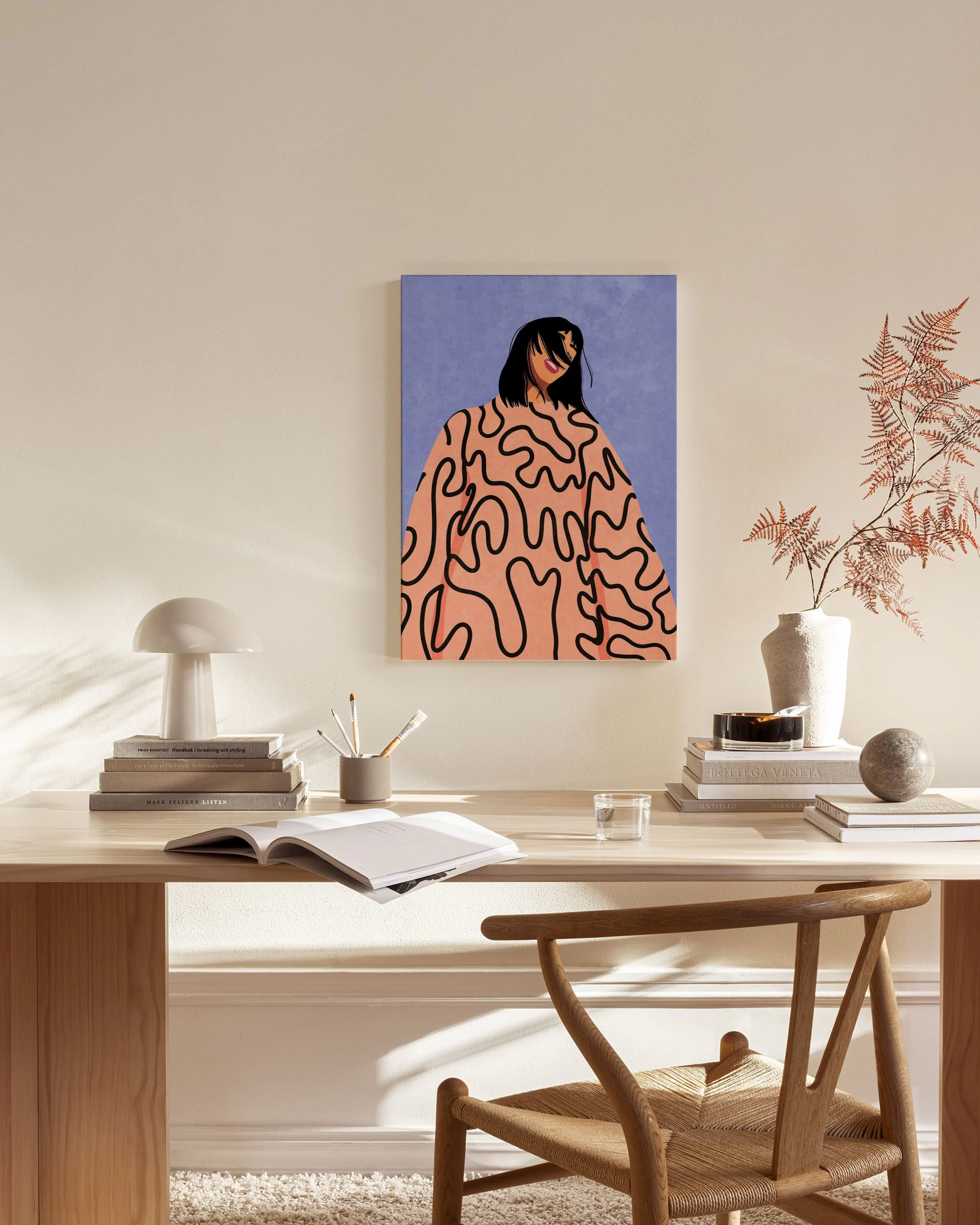 A canvas print of a woman in a pink top with black squiggly lines on a purple background, displayed in a bright living room.