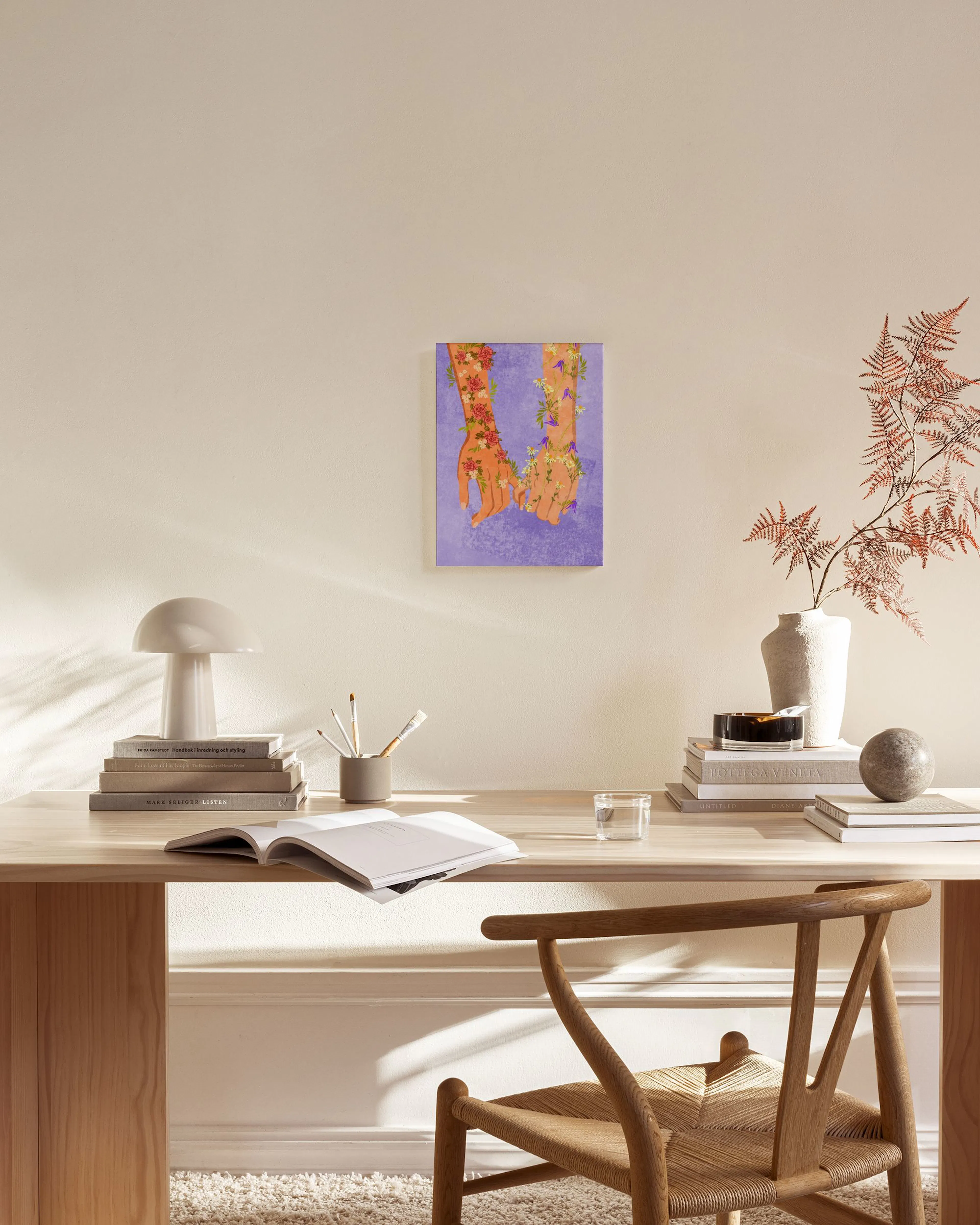 Leinwandbild mit zwei sich haltenden Händen voller Blumen auf lila Hintergrund, hängend über einem Sideboard in einem Wohnzimmer