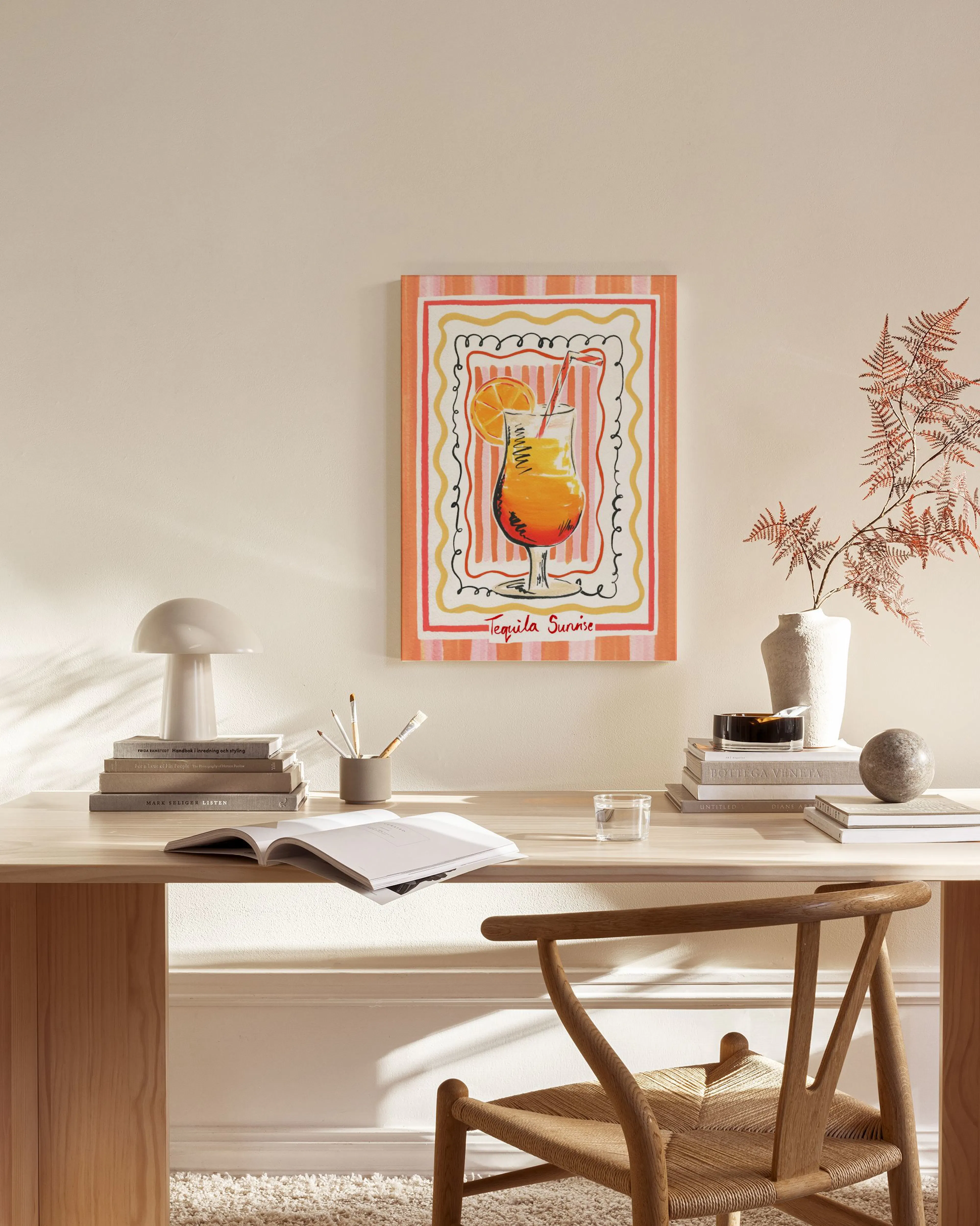 Stampa su tela di un cocktail Tequila Sunrise con bordi ondulati, esposta in un soggiorno moderno.