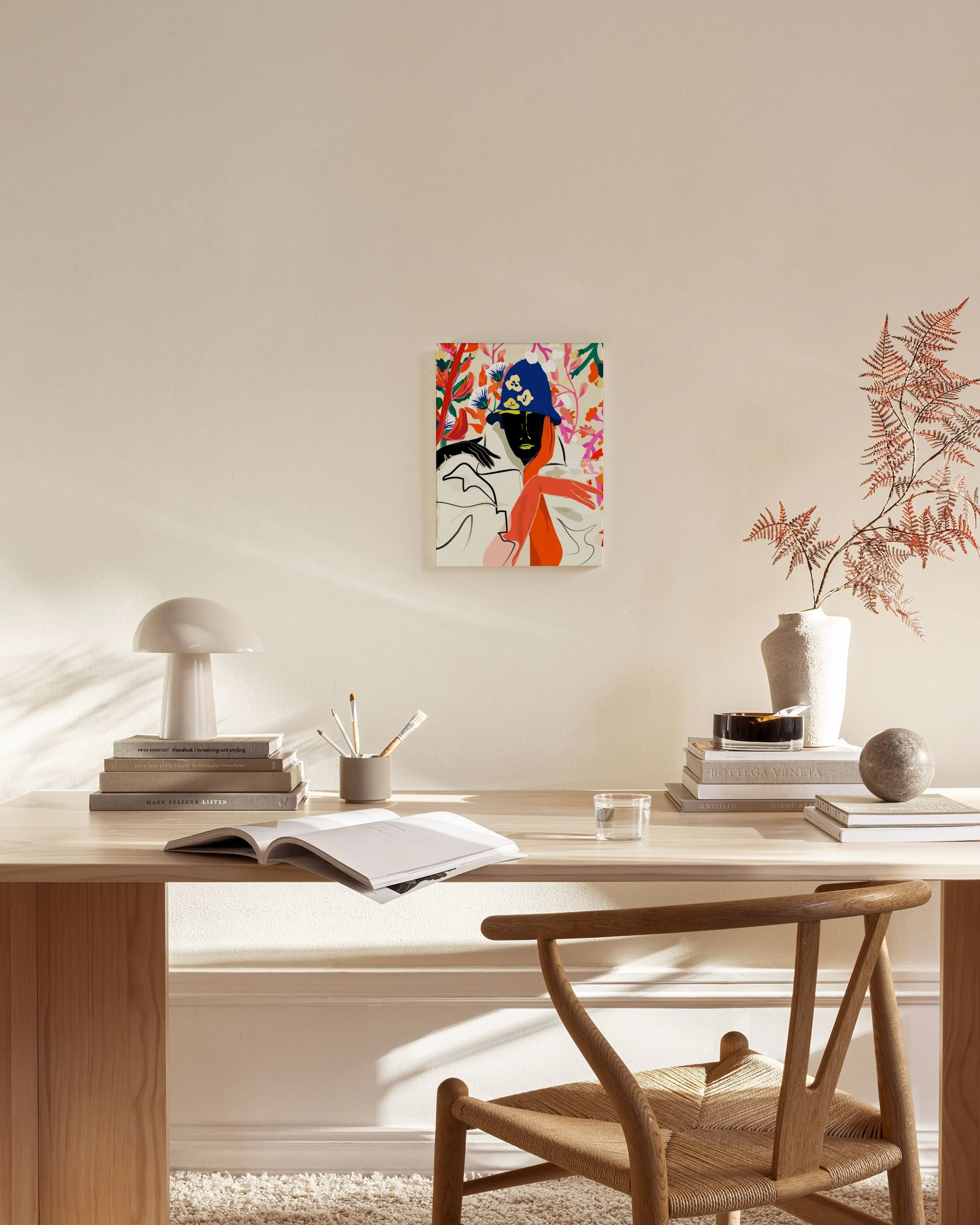 Colorful canvas print of a woman with a blue hat and orange arm, displayed in a bright living room above a wooden console.