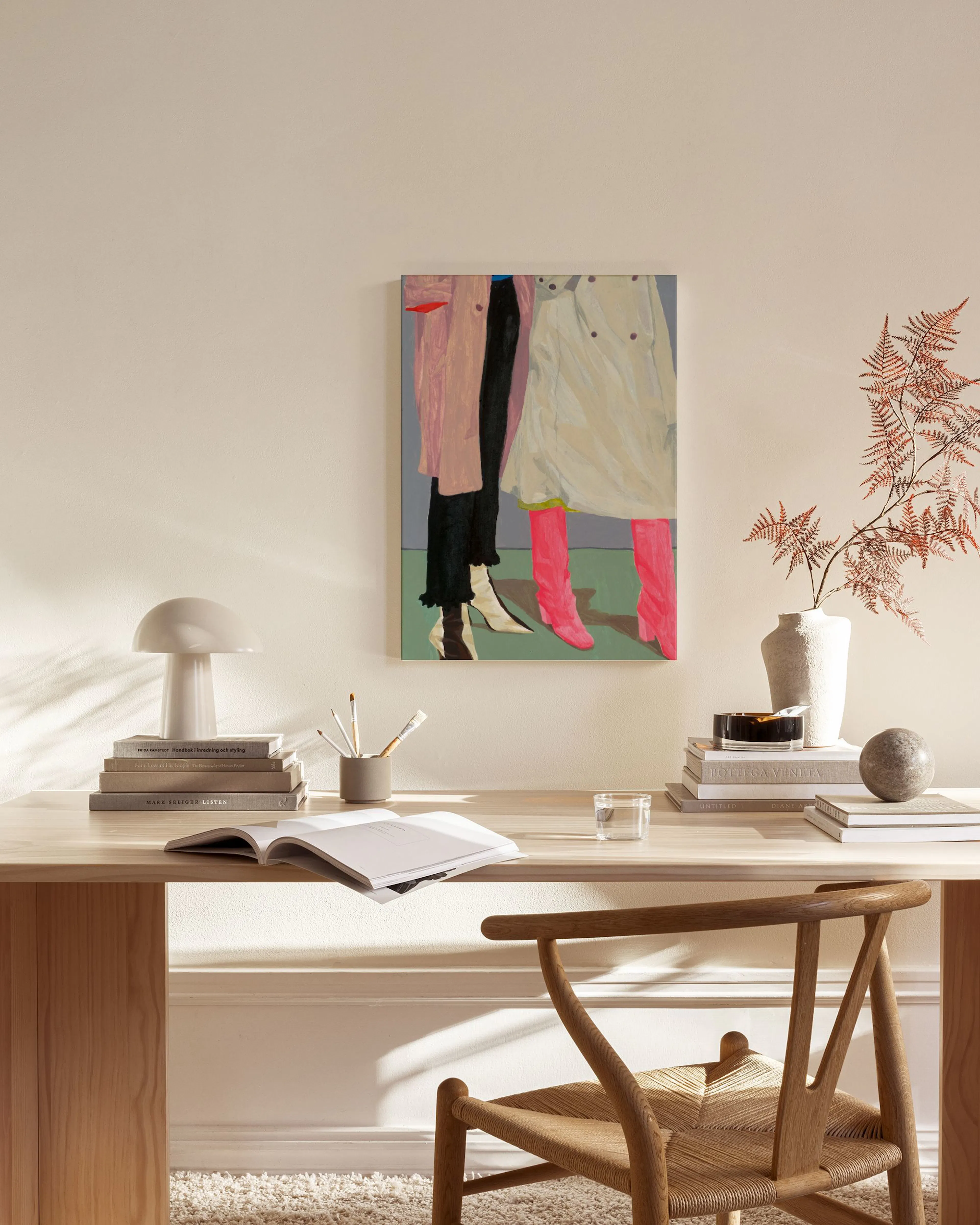 A painting of two figures in coats and boots, one with pink boots, hanging above a console table in a modern living room.