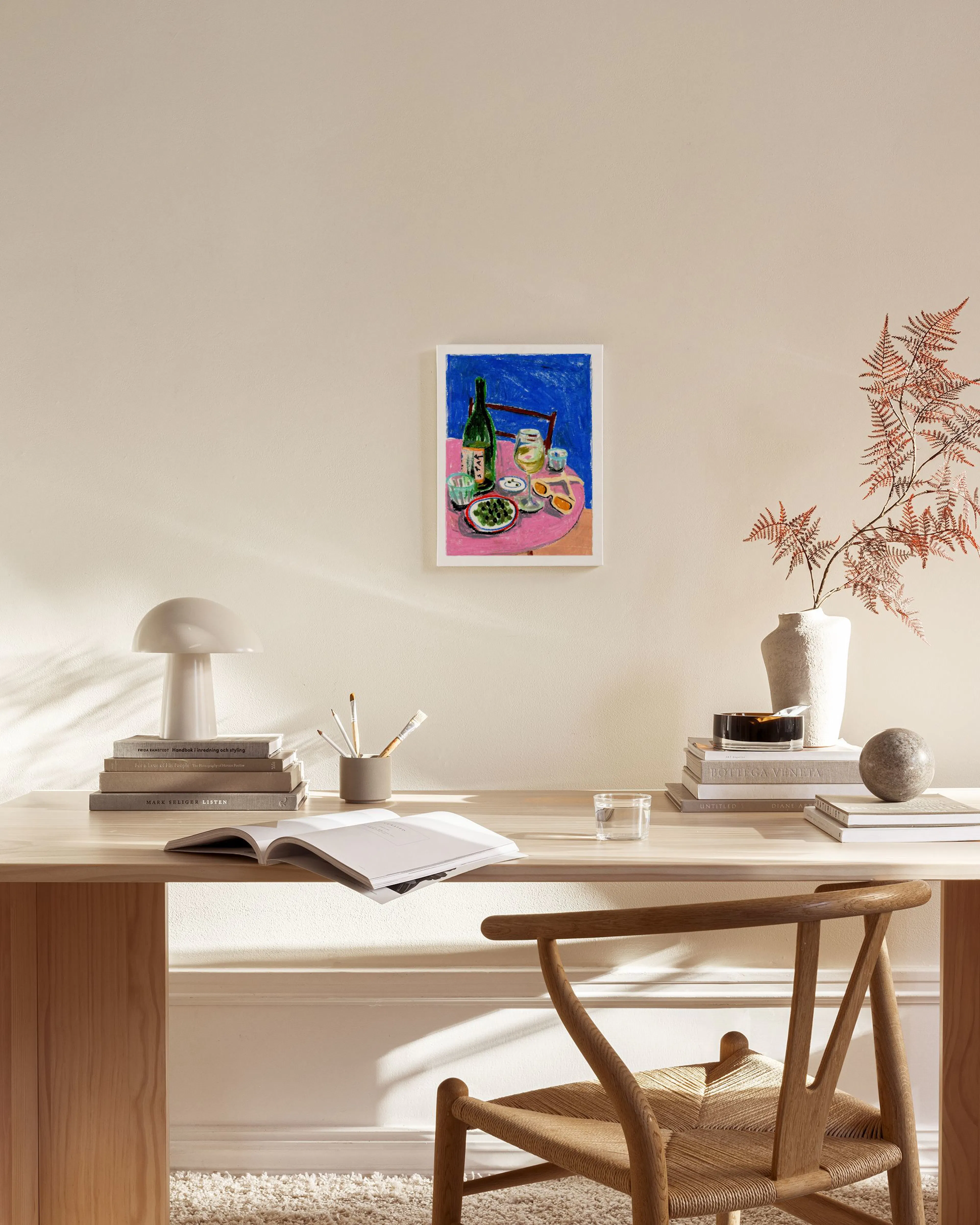 Canvas van een fles wijn, glas en schaal met olijven op een roze tafel, hangend in een moderne woonkamer.