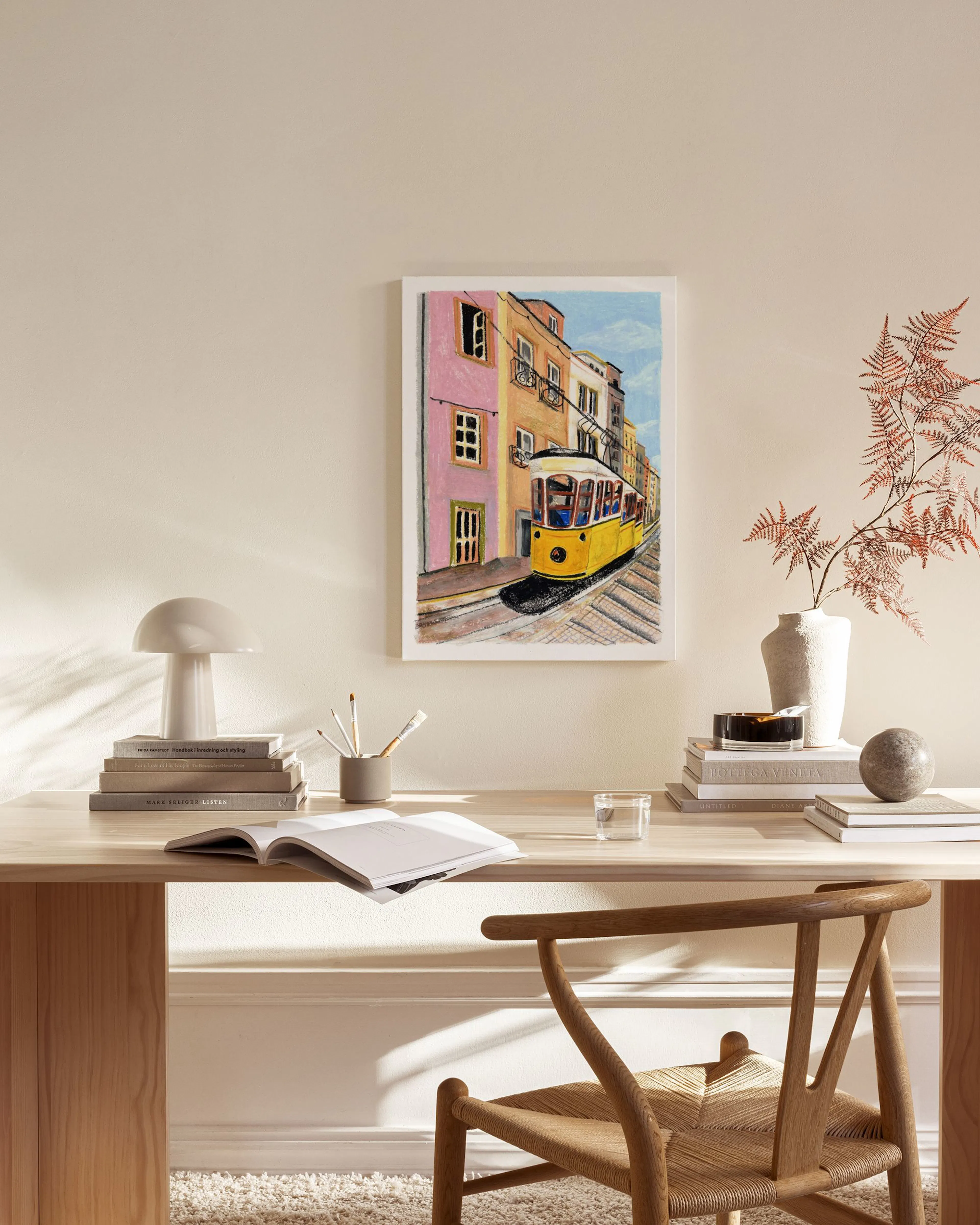 Leinwandbild mit gelber Straßenbahn in bunter Gasse, hängend über einem Sideboard im Wohnzimmer.