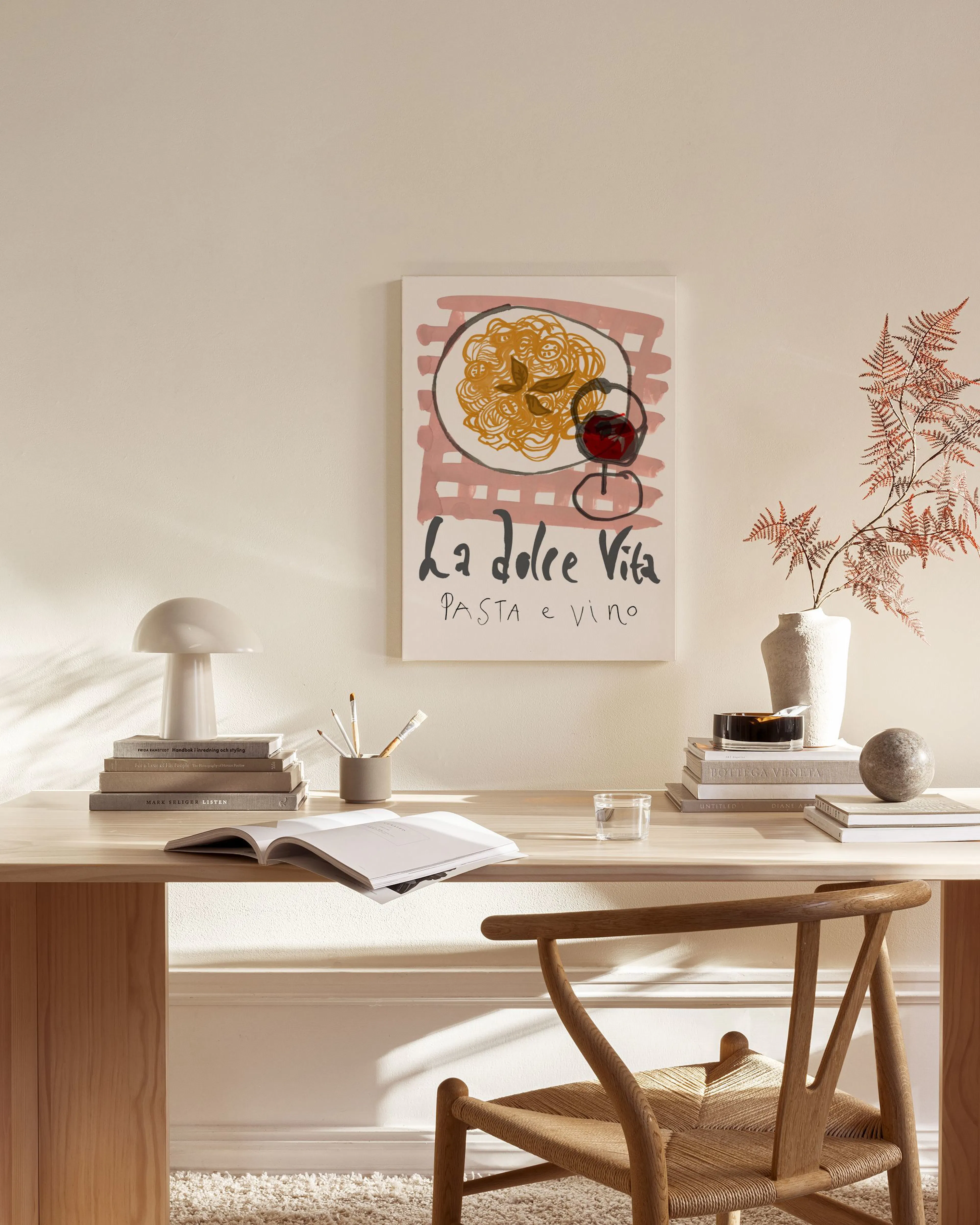 An Italian food and wine art print with La dolce Vita PASTA e VINO text, hanging in a light minimalist living room.