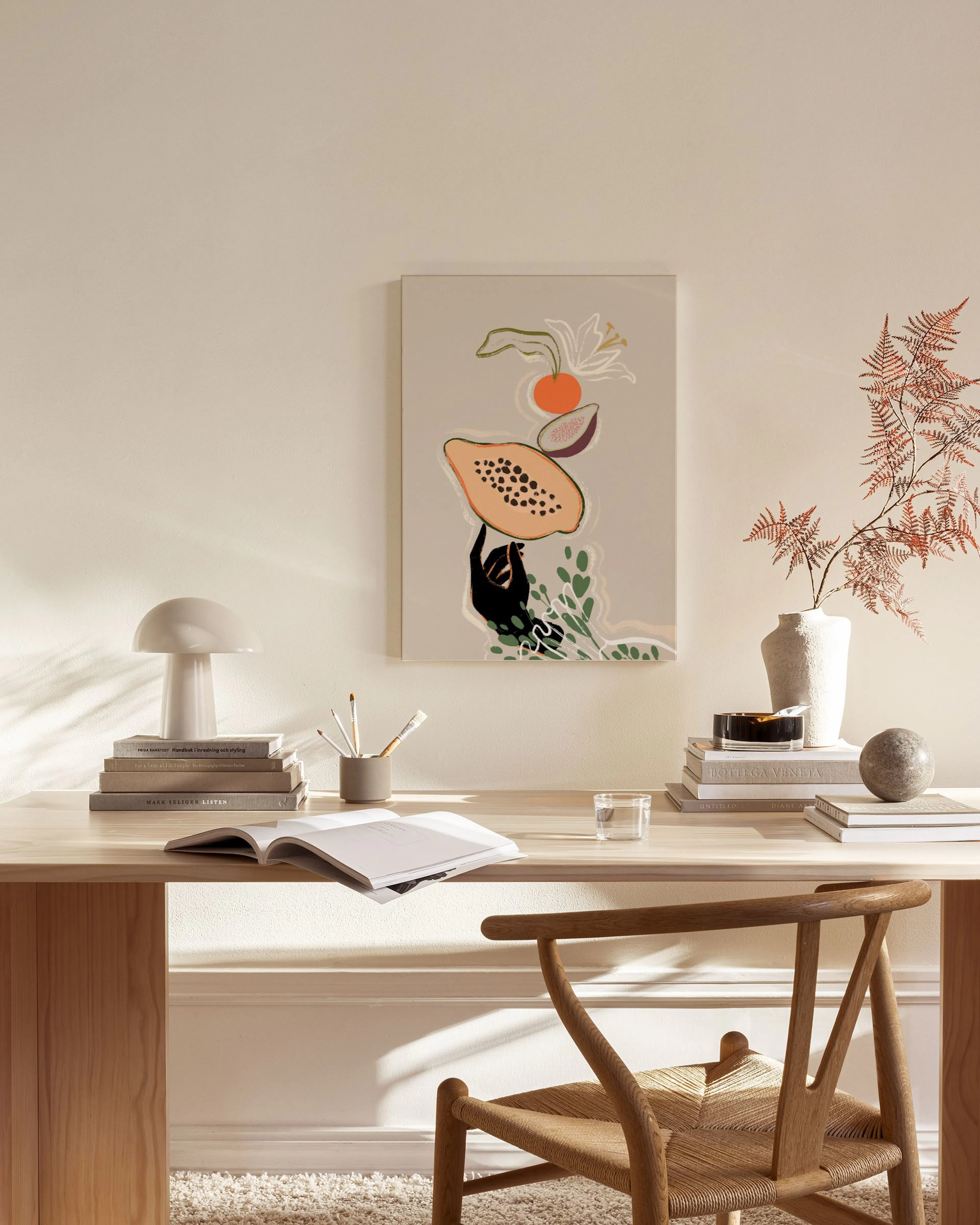 Canvastavla med illustration av papaya, fikon och lök i jordnära färger, hängande i ett ljust vardagsrum.